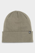The 686 Standard Roll Up Beanie by 686 is a light olive green knit hat with a folded brim and a small black fabric tag featuring a white logo on the side, displayed against a plain white background.