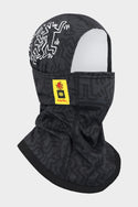 The 686 Alpha Hinged Balaclava (WN2526 Copy) features a black and gray pattern with abstract white designs, includes a yellow patch with a red 686 logo and text on the side, covers the neck and lower face, and has an open top exposing its white interior lining.