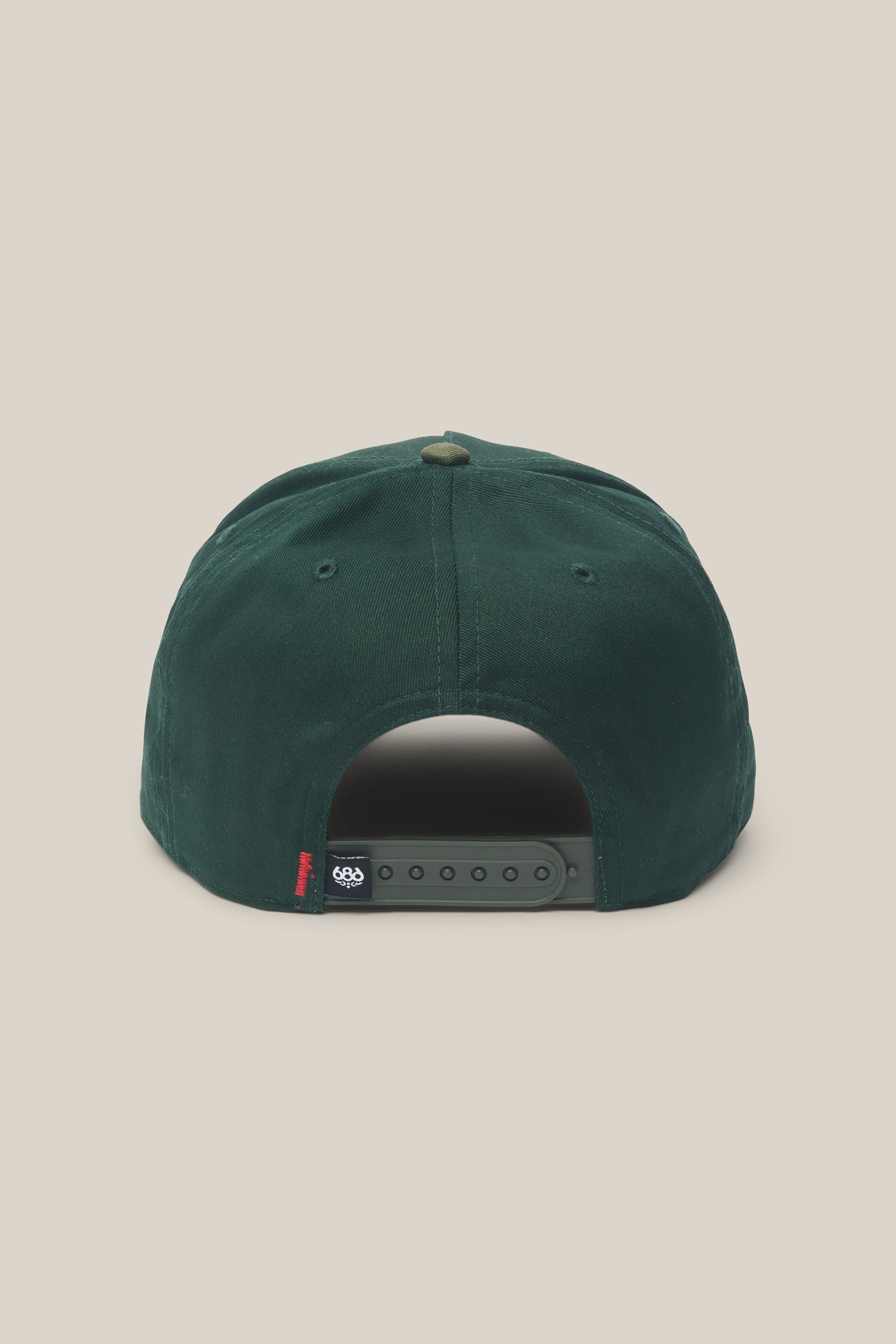 The 686 High-Pro Ses Two Tone Structured 5 Panel Hat by 686 is displayed from the back in dark green, featuring a 100% cotton construction, an adjustable strap with snap closures, and a small black tag with white text on the left side.