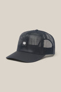 The 686 High-Pro Knockout Structured 5 Panel Hat by 686 is a black mesh men's cap with a curved brim and a small rectangular white logo patch on the front, shown against a light beige background.