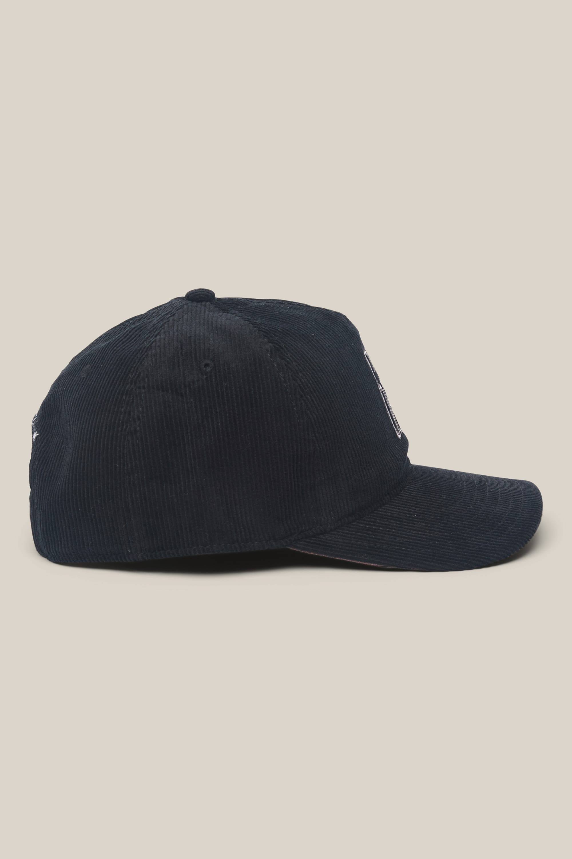 The 686 Mid-Pro Ghost Cord Unstructured 5 Panel Hat by 686, a men's navy blue corduroy cap, is displayed from the side against a plain beige background.