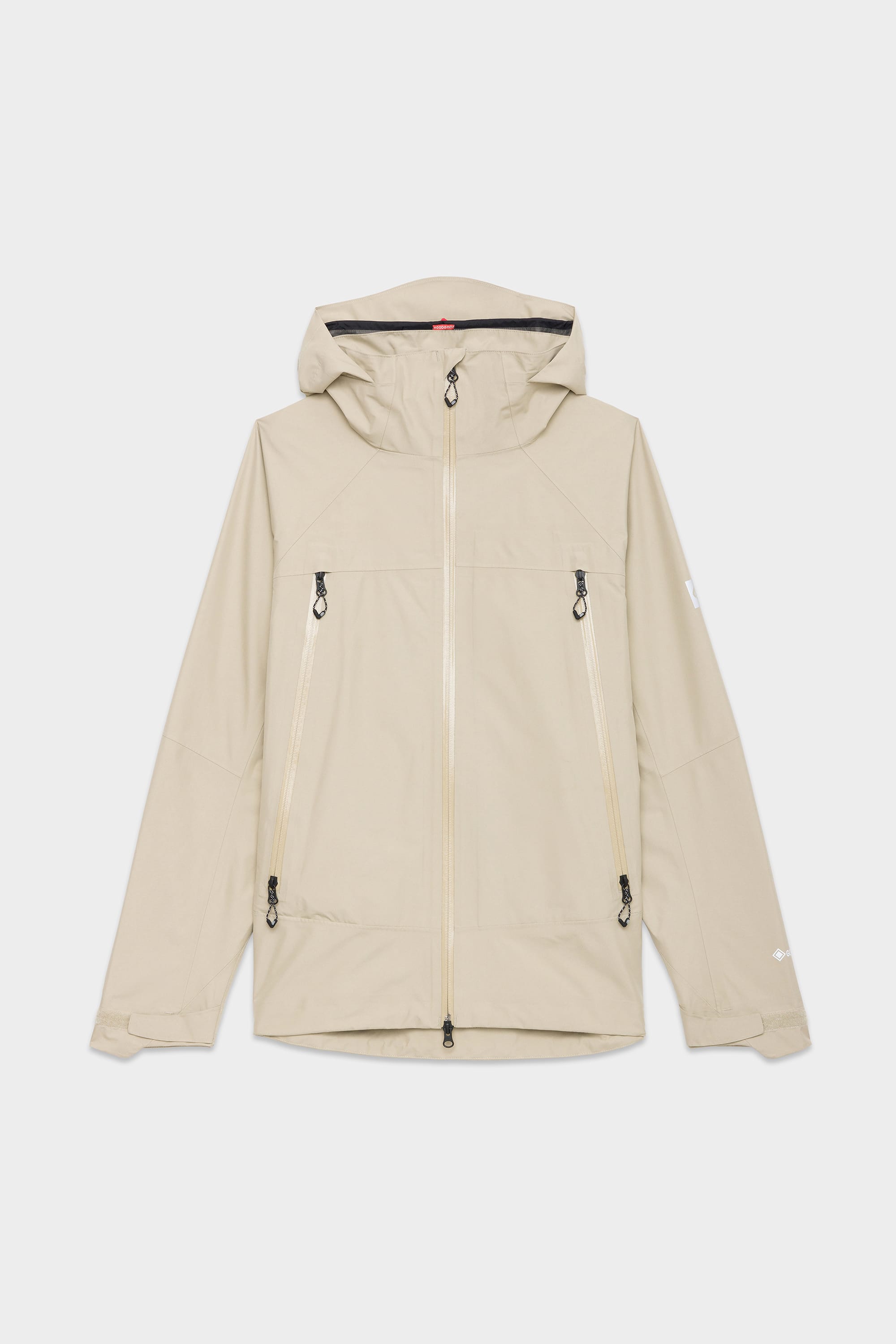 The 686 Mens GORE-TEX PACLITE® Jacket in light beige features a front zipper, two vertical zippered chest pockets, side zippered pockets, and long sleeves. Shown laid flat on a white background.