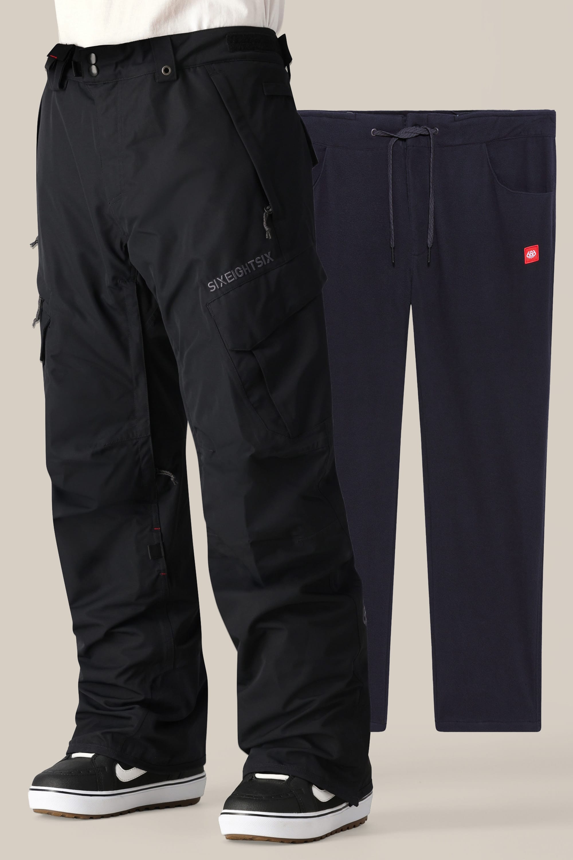 A person wearing the 686 Men’s SMARTY® 3-in-1 Cargo Pant and black-and-white sneakers stands next to a pair of dark blue sweatpants with pockets and a drawstring, displayed against a light beige background.