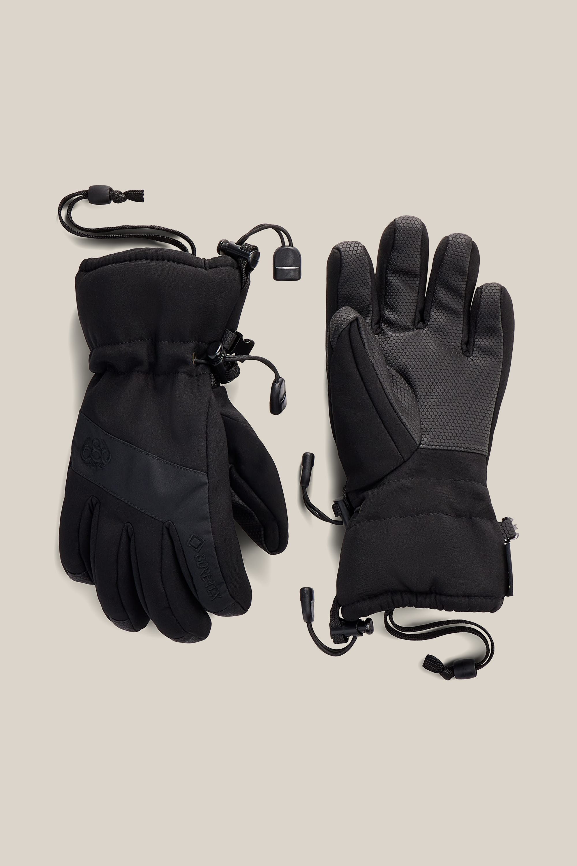 A pair of 686 Youth GORE-TEX® Linear™ Gloves with adjustable wrist cords and textured palms, displayed on a light beige background.
