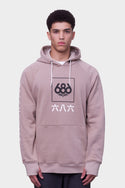A young man wears the 686 Mens Script Knockout Hoody, featuring a beige color, black and white 686 logo with Asian characters on the front, white drawstrings, and a kangaroo pocket, standing against a plain white background.