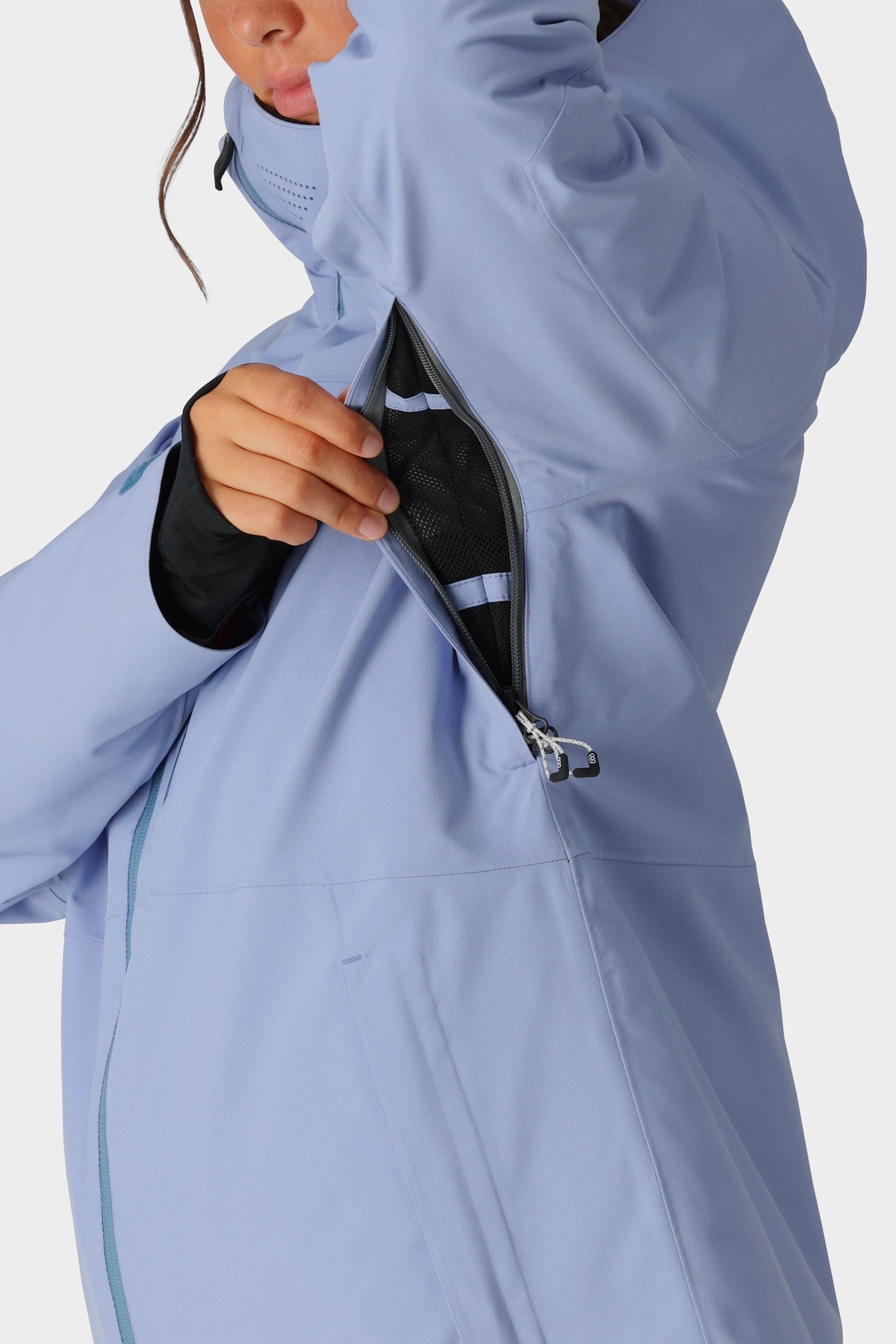 A person unzips the underarm vent of the 686 Womens Hydra Insulated Jacket, revealing the black mesh lining inside this best-selling waterproof jacket by 686.