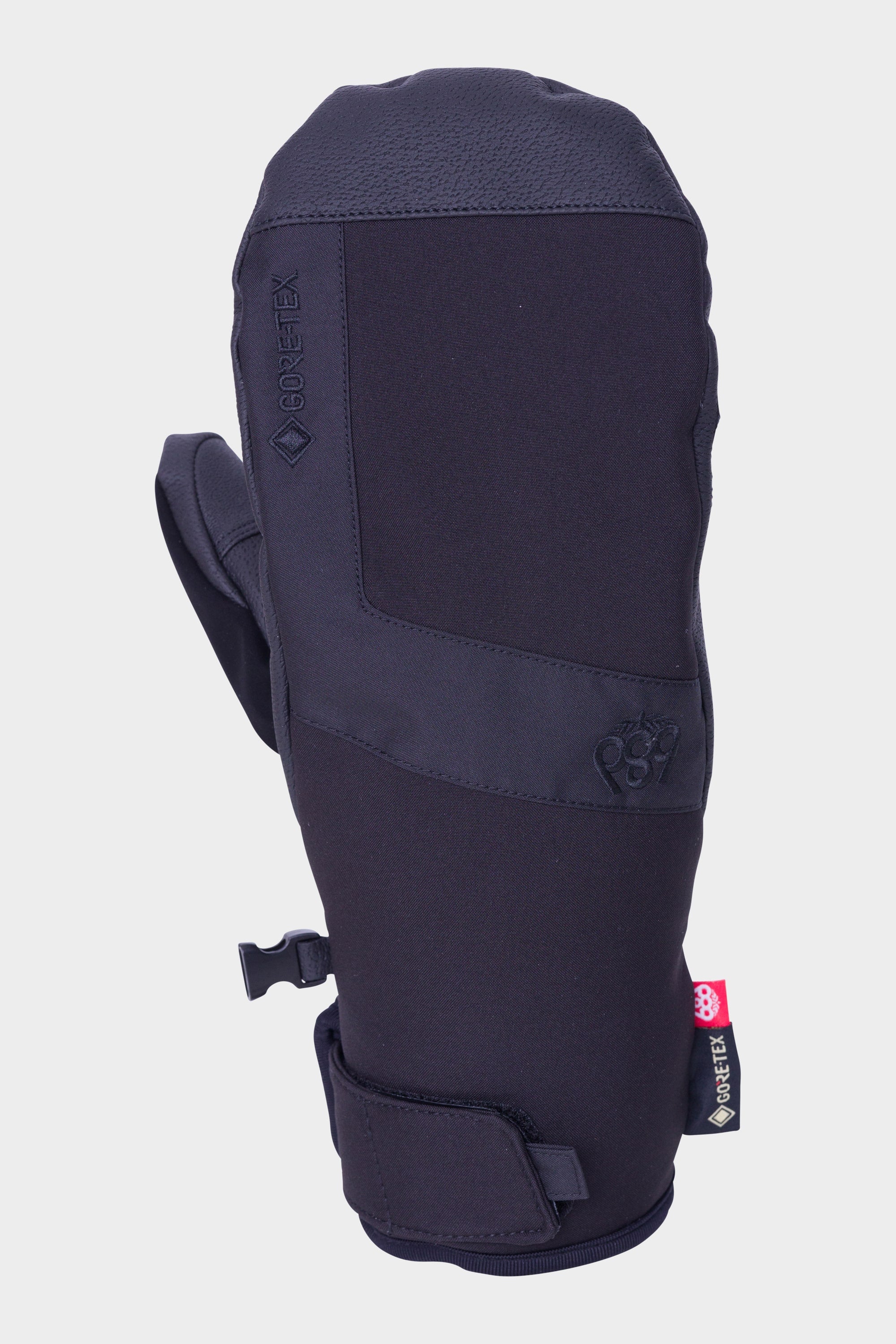 The 686 Mens GORE-TEX Linear Under Cuff Mitt by 686 is a black mitt featuring reinforced stitching, an adjustable wrist strap, and a mitten clip, designed for waterproofing and warmth. Shown on a plain white background.