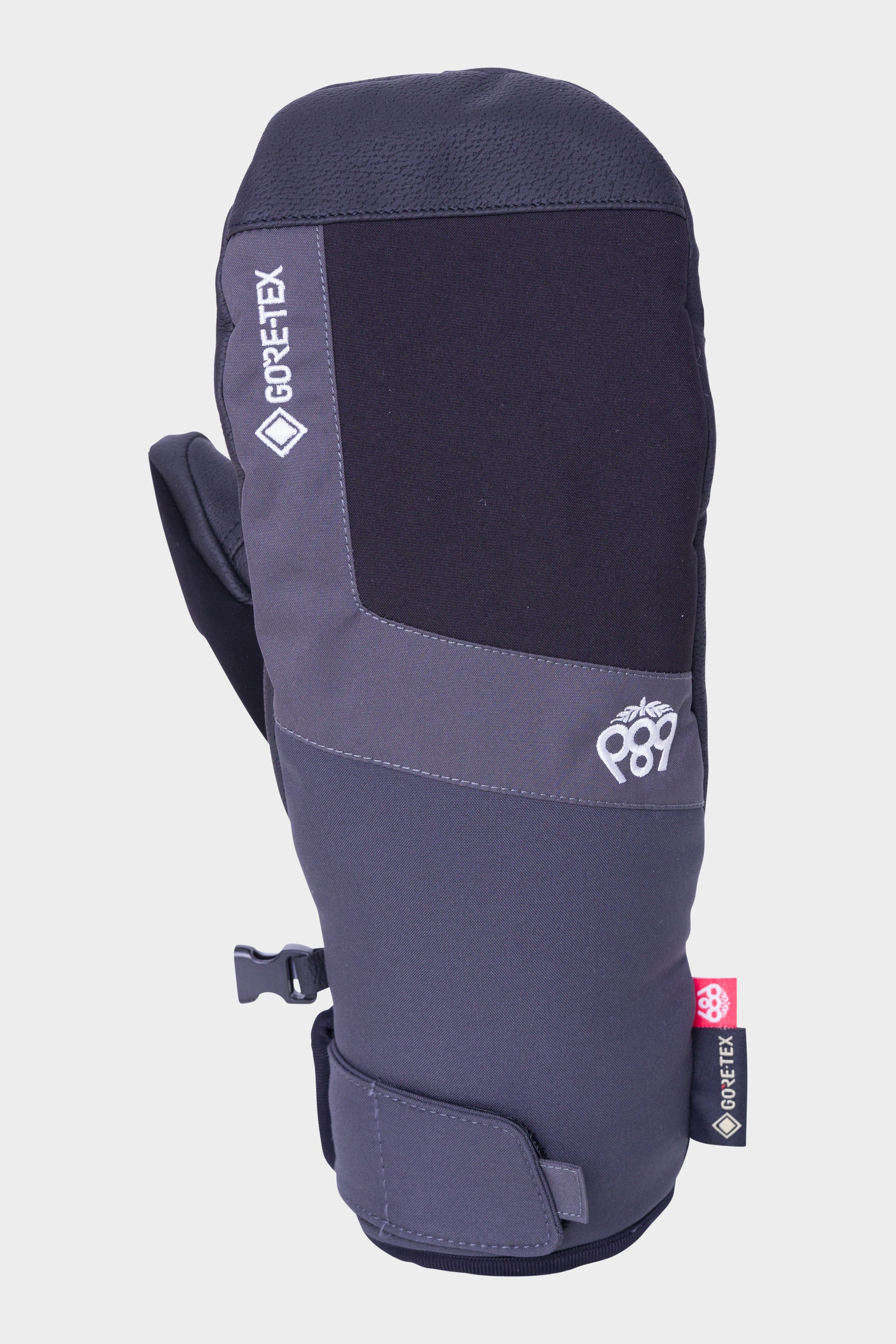 The 686 Mens GORE-TEX Linear Under Cuff Mitt features gray and black colors, a GORE-TEX tag for waterproofing, the 686 logo, and a velcro wrist strap—designed to deliver reliable protection in cold weather.