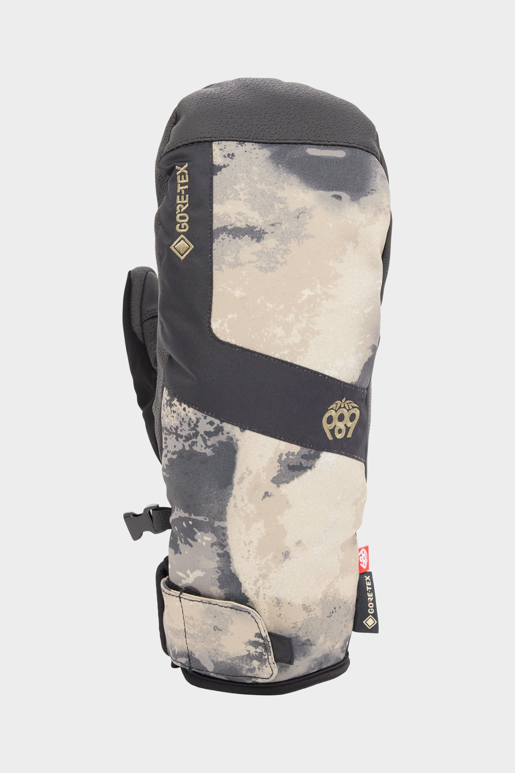 The 686 Mens GORE-TEX Linear Under Cuff Mitt features a gray and beige camo design with black accents, GORE-TEX branding, waterproof padding, and a wrist strap for adjustable fit.