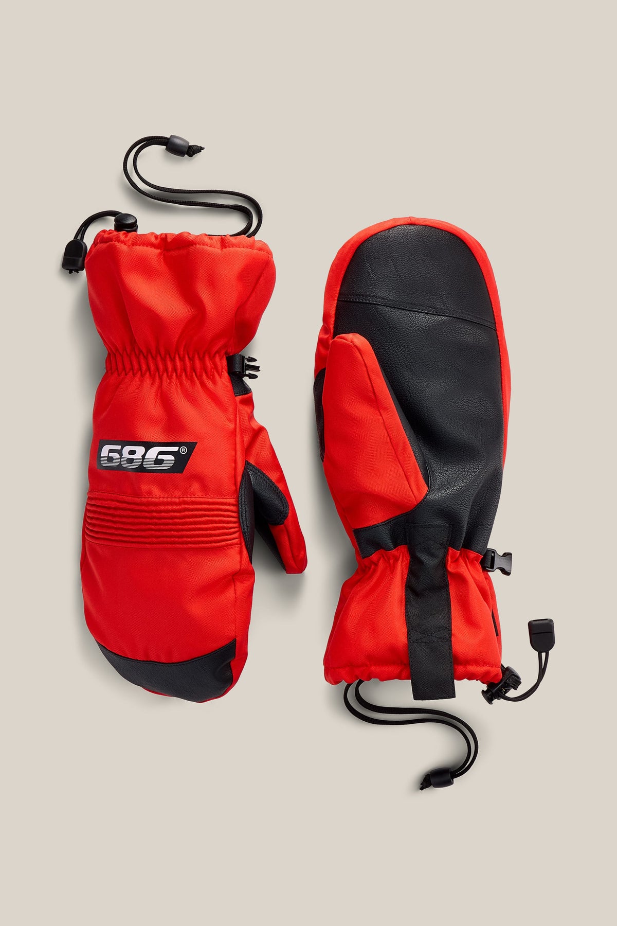 A pair of 686 Lander™ Mitts in red and black, featuring insulated construction, adjustable wrist straps, and cords. Displayed on a light beige background, one mitten shows the palm side while the other displays the back with a prominent 686 logo patch.