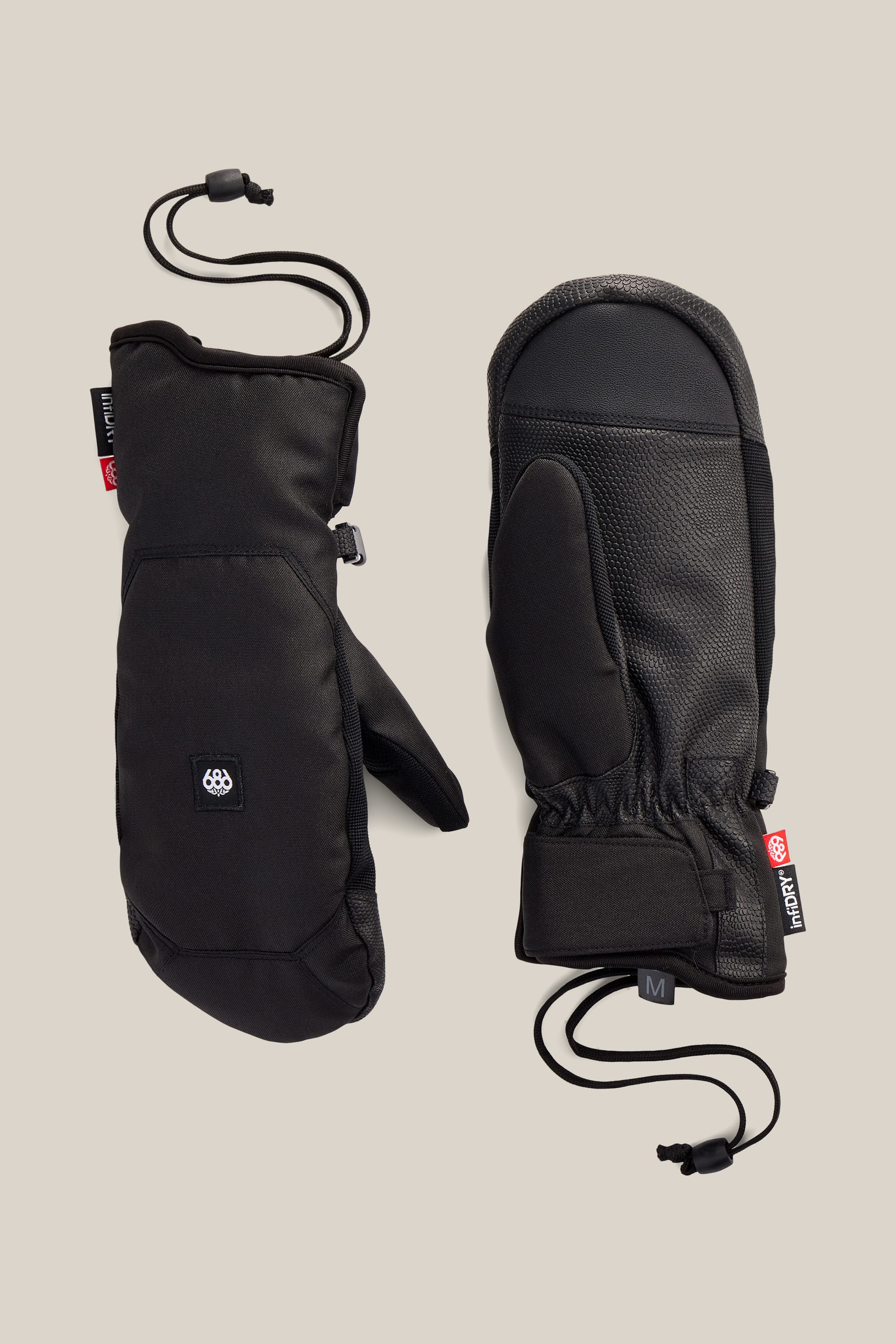 The 686 Women’s Revel Mitt by 686 is shown in both front and back views against a neutral background, featuring a black design with adjustable wrist cords and textured palms.