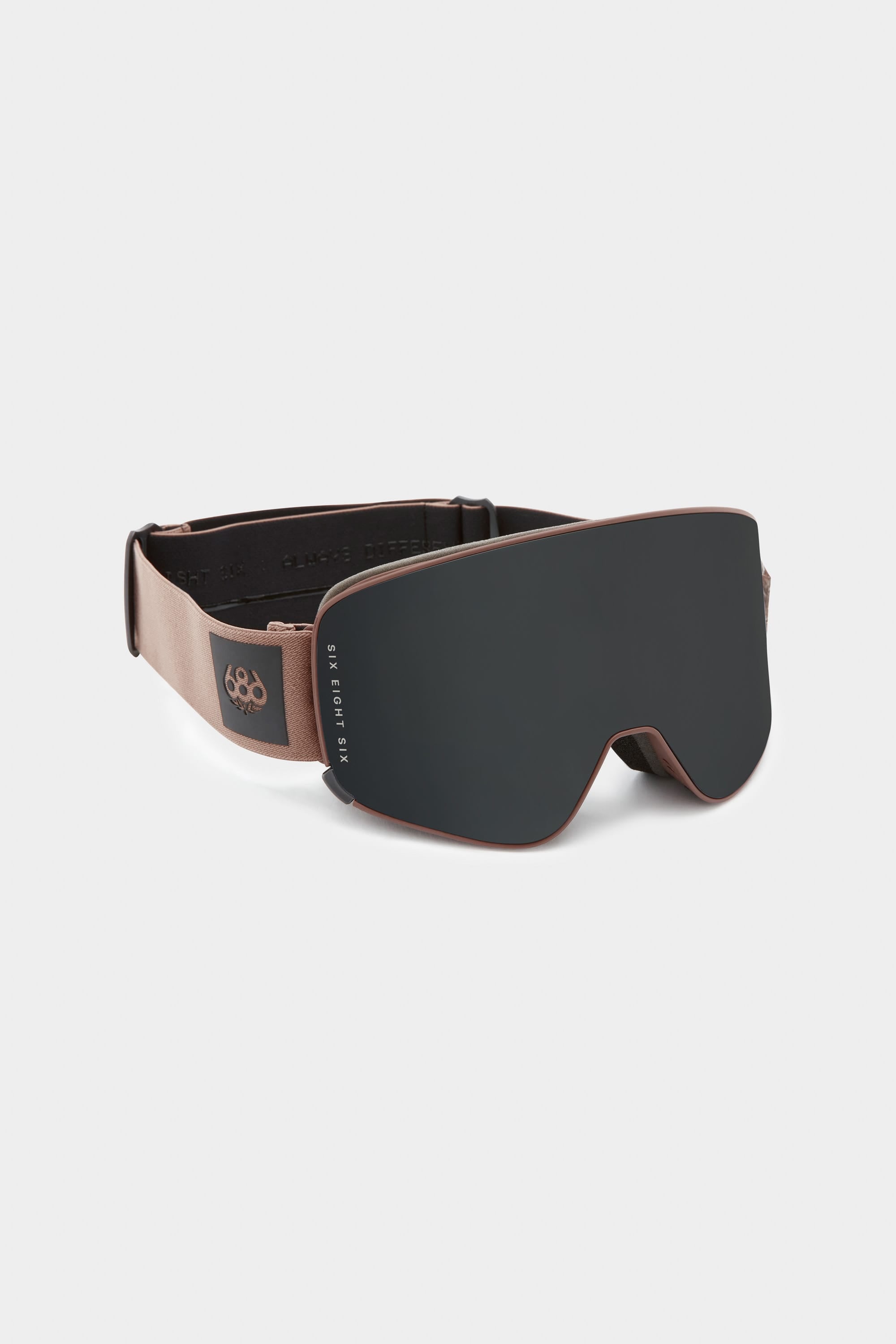The 686 SMARTY Goggle by 686 features a sleek black design, wide dark magnetic lens, brown adjustable strap with logo, and suits all conditions, shown on a white background.