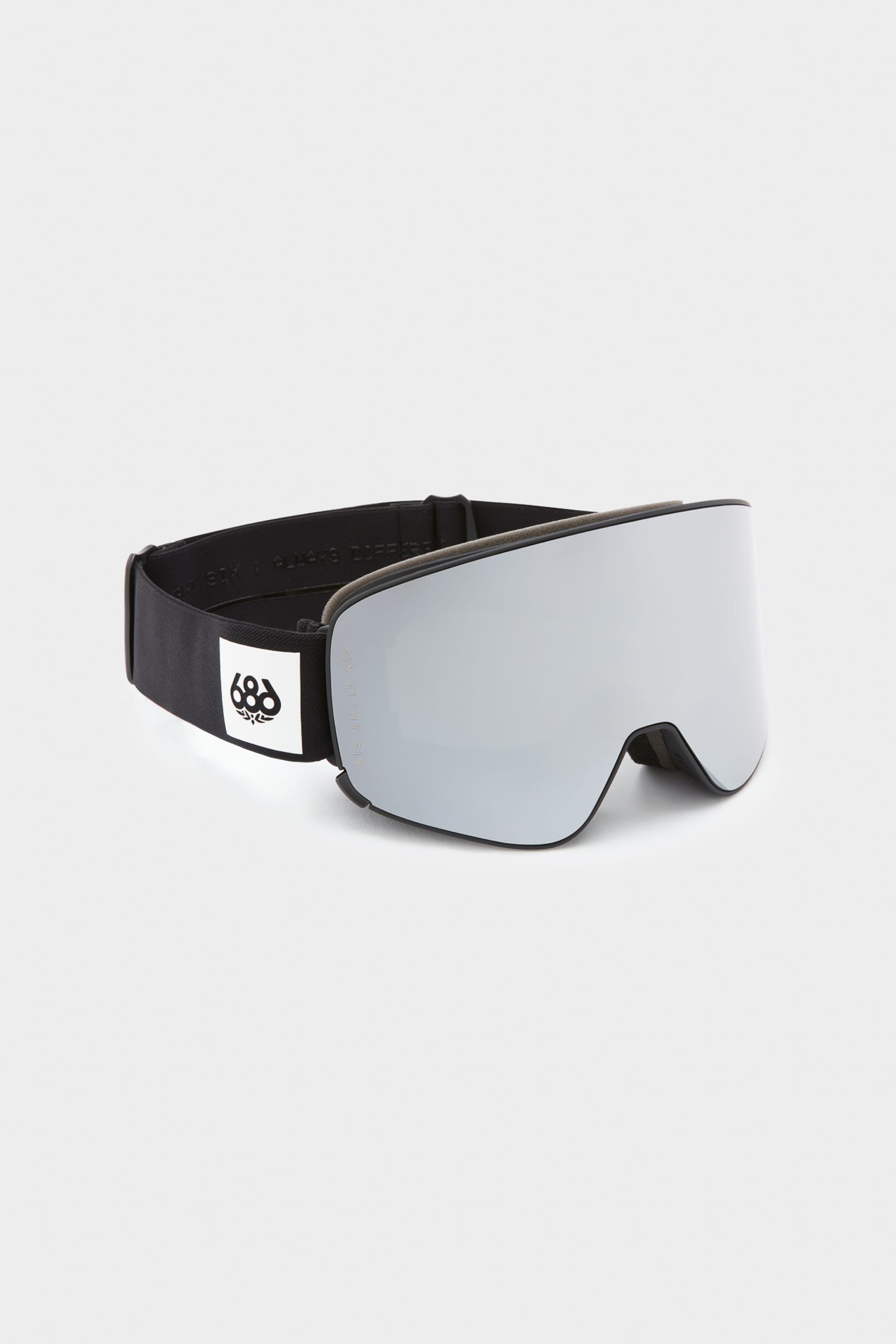 The 686 SMARTY Goggle by 686 features a minimalist design, wide reflective lens, magnetic quick-swap system, and a black adjustable strap with a white patch and black 686 logo. Shown on a plain light gray background.