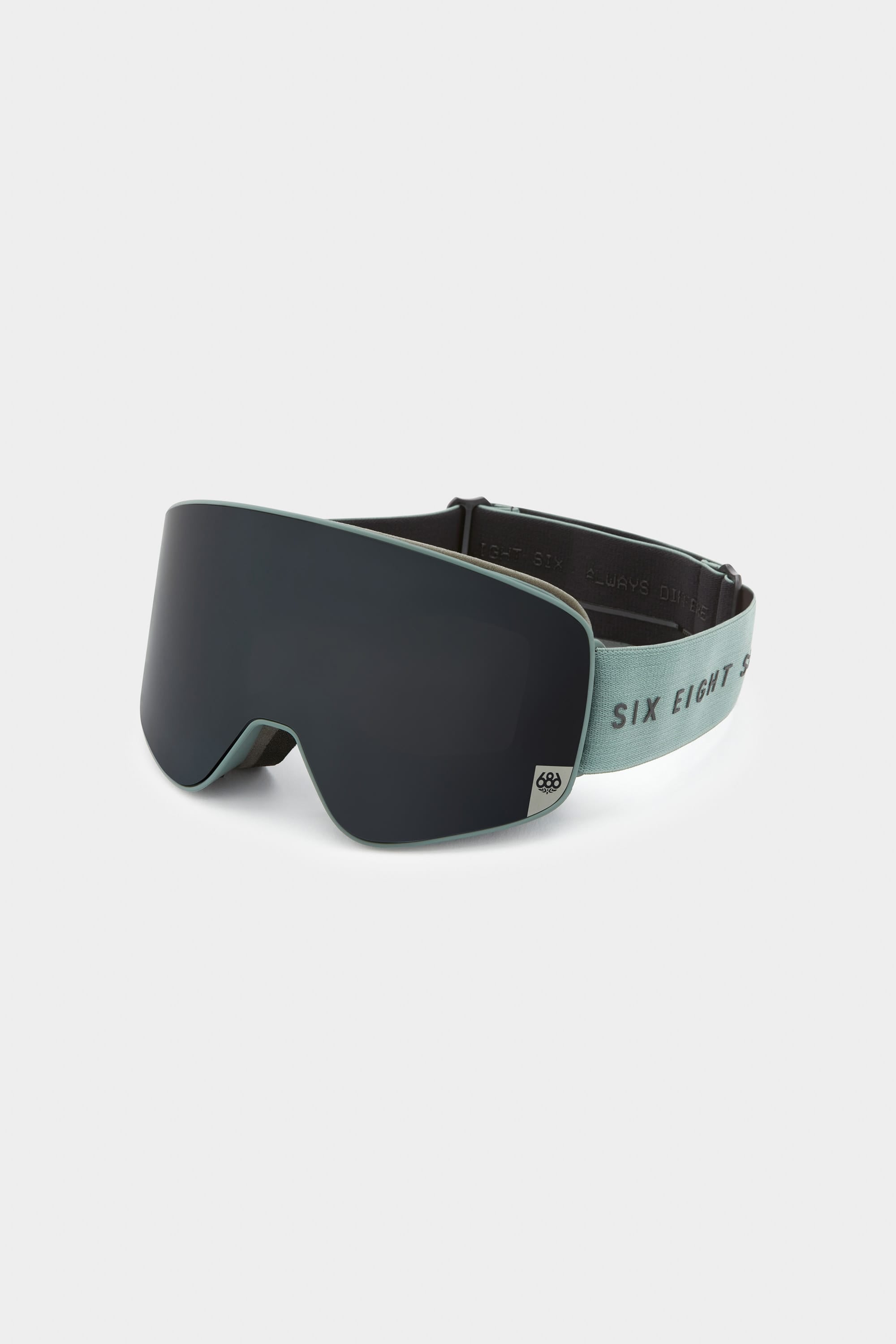The 686 SMARTY Goggle by 686 features a matte black minimalist design, wide curved magnetic lens, and light green adjustable SIX EIGHT strap for a modern look and quick lens swaps in any slope conditions.