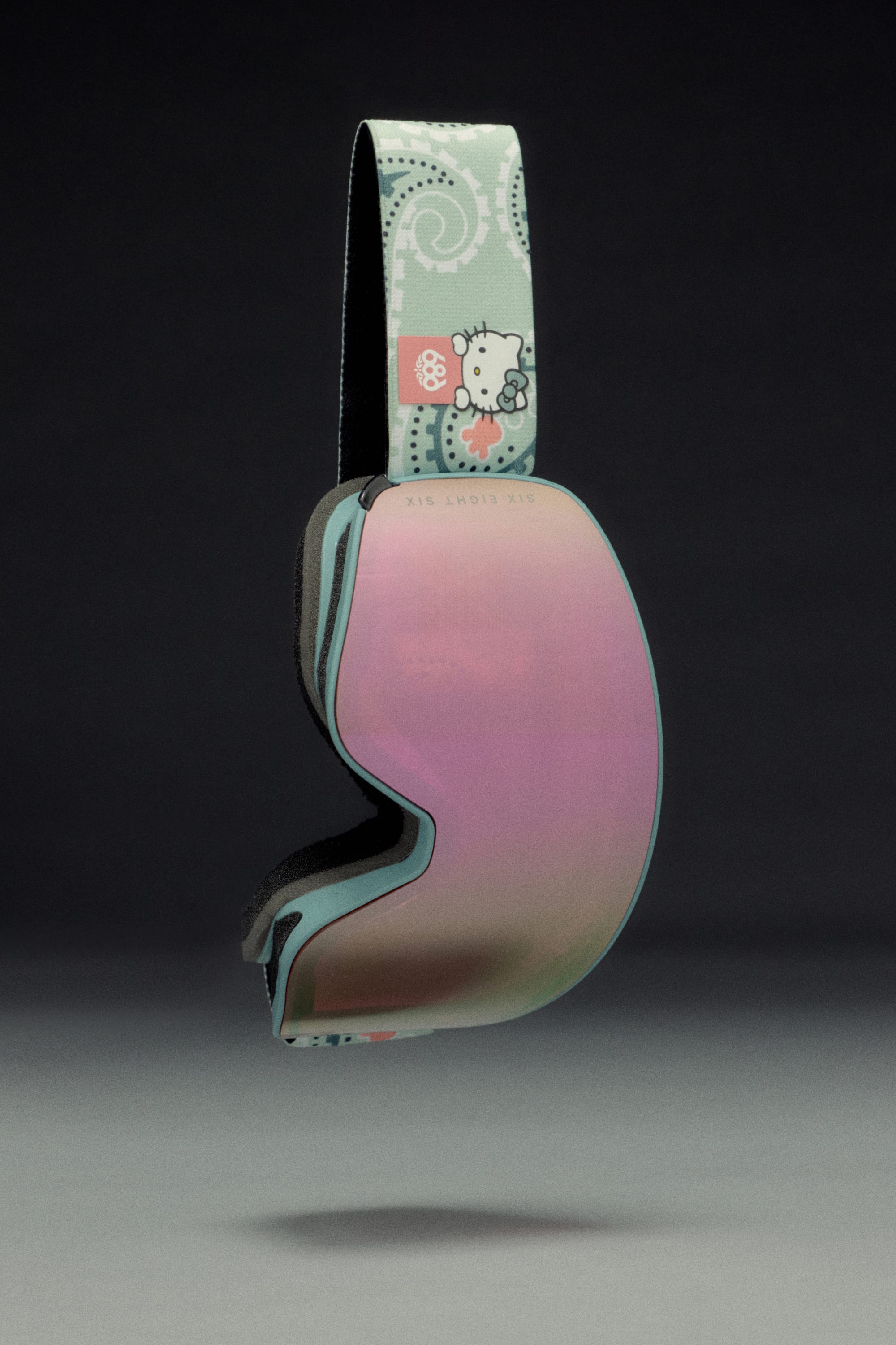 The 686 SMARTY Goggle by 686 features a pastel minimalist design with a pink-tinted lens and a Hello Kitty strap in light blue patterns, shown on a dark gray background. Magnetic lenses offer easy swaps for any conditions.