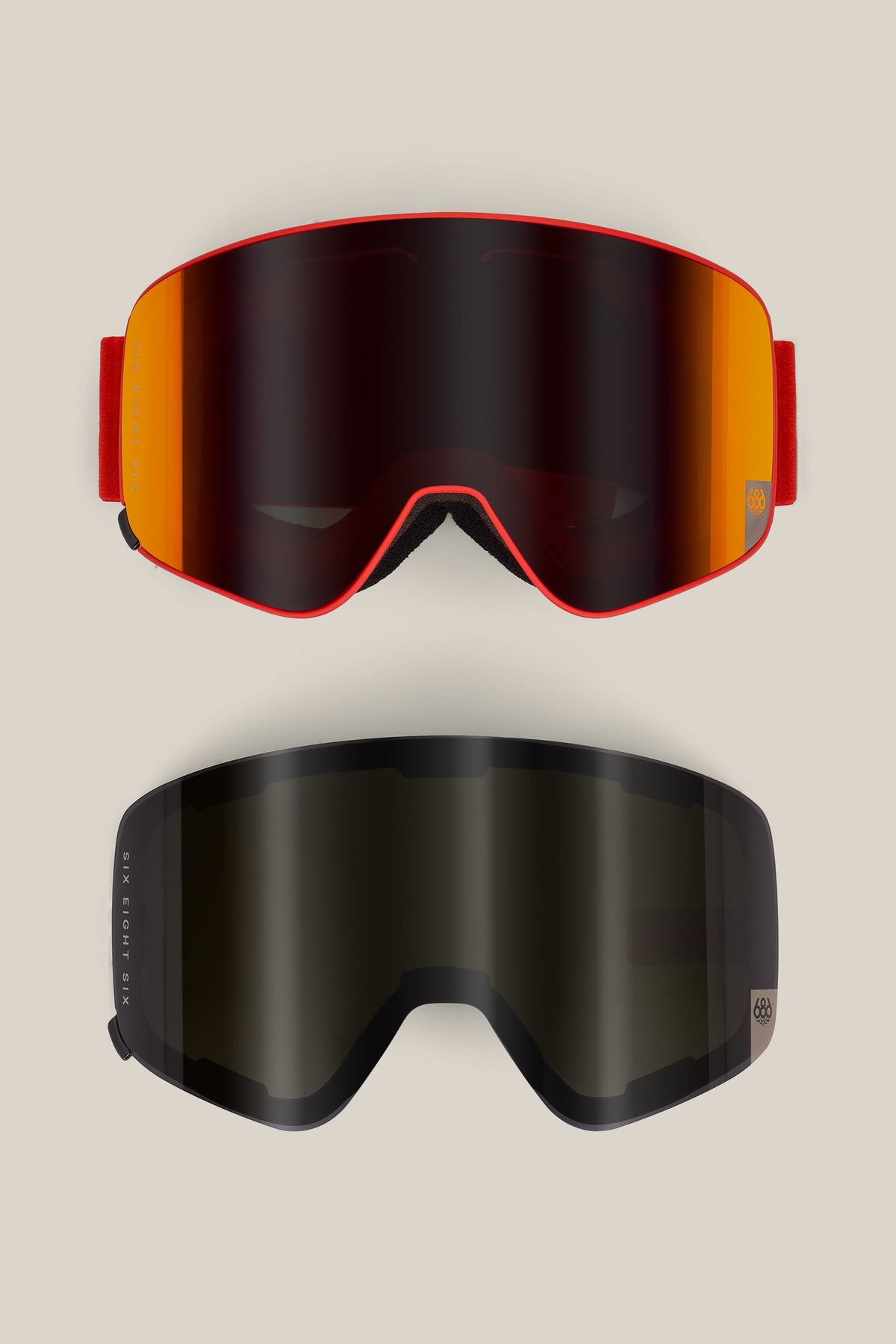 Two pairs of 686 SMARTY® Magnetic Goggles are displayed on a plain background: the top pair features a red frame with an orange mirrored lens, while the bottom pair has a black frame with a dark lens.