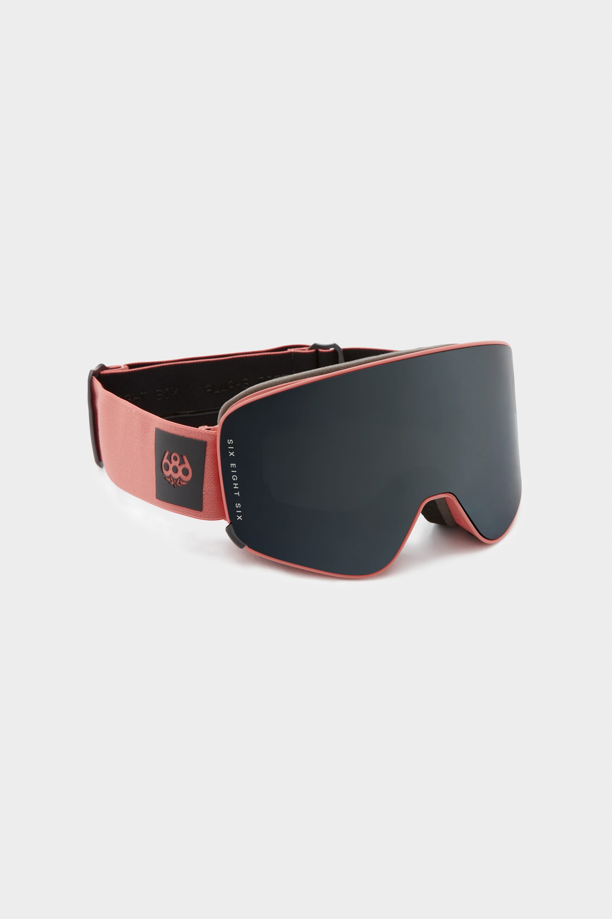 The 686 SMARTY Goggle by 686 features a modern minimalist design with a wide, dark-tinted magnetic lens and a red adjustable strap with a small white logo, suitable for all conditions and shown against a light background.