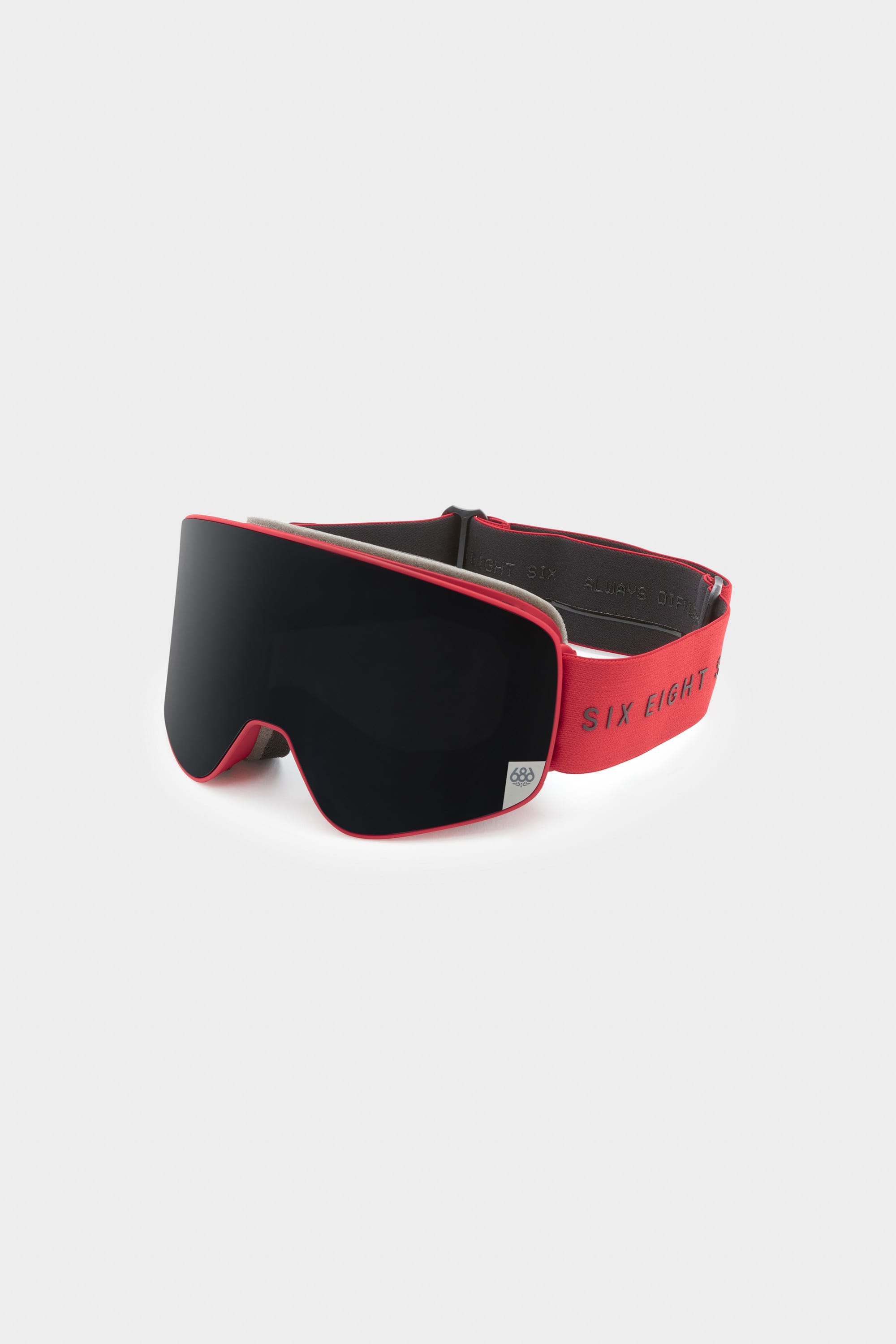 The 686 SMARTY Goggle by 686 features a red minimalist design, wide dark-tinted lens, and adjustable red strap with SIX EIGHT text. Suitable for all conditions, its showcased on a plain light gray background.