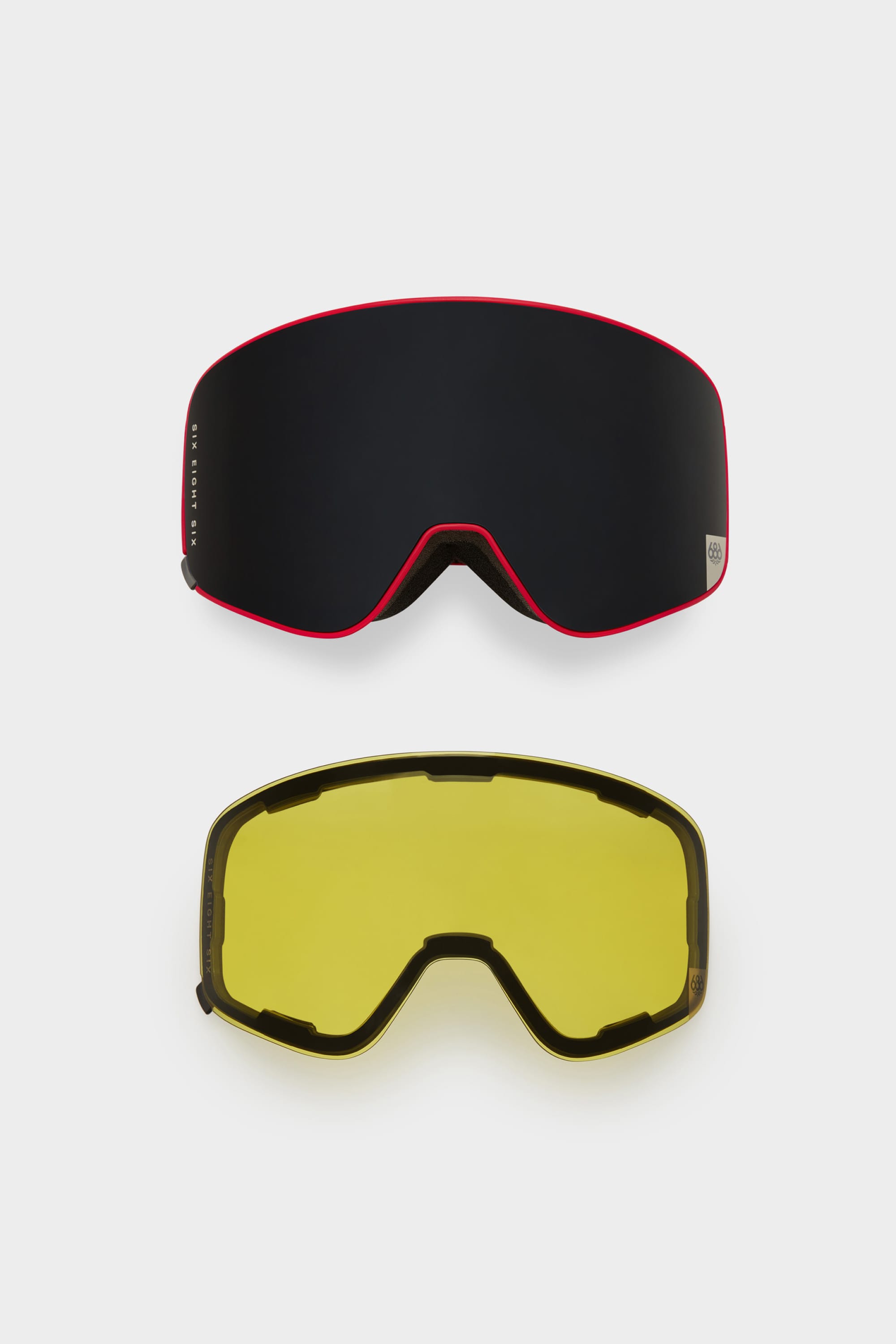 The 686 SMARTY Goggle by 686 features two interchangeable minimalist lenses—one black with a red rim, the other yellow with a black rim—displayed on a plain white background. Both are designed for all conditions and feature easy-to-swap magnetic lenses.