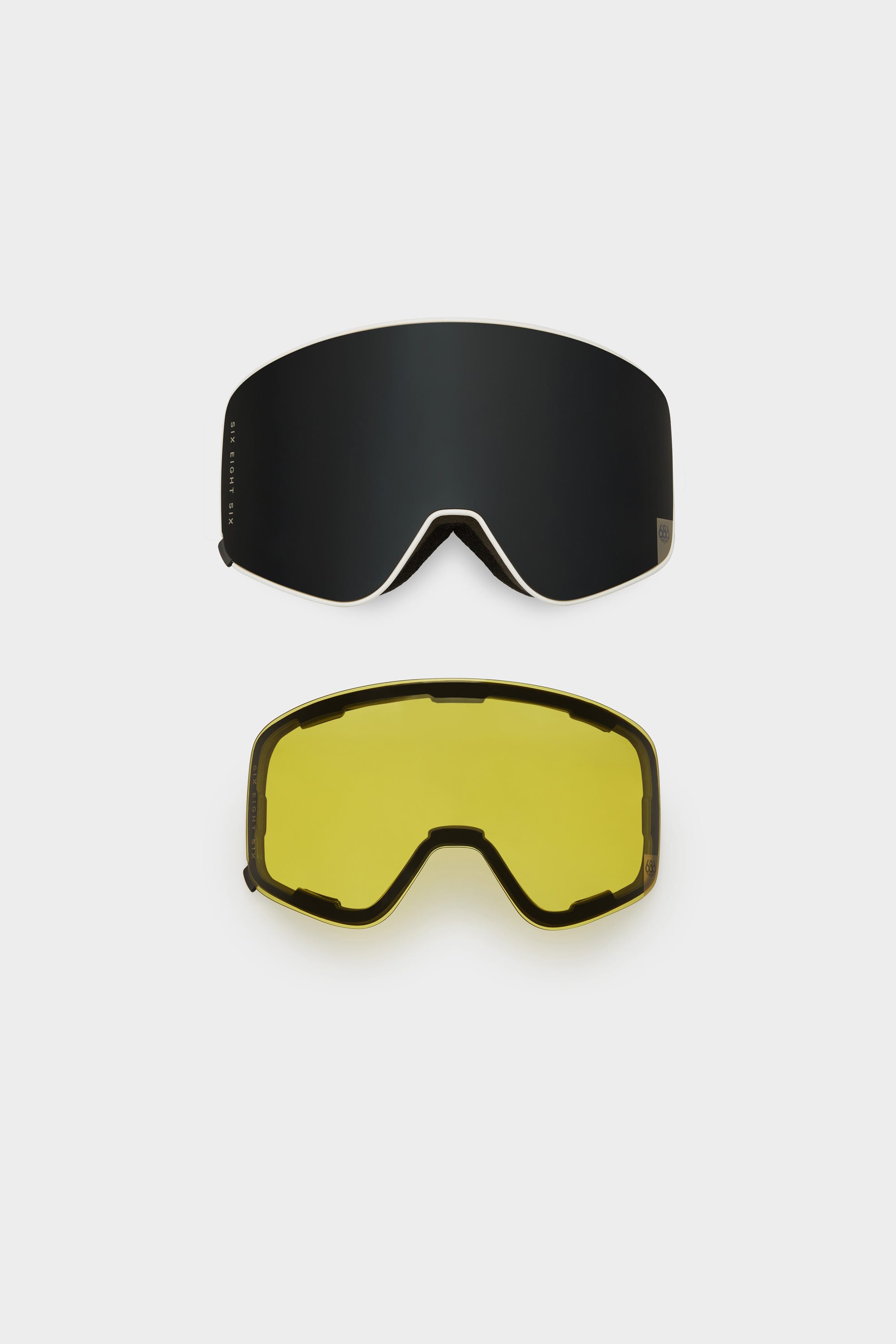 The 686 SMARTY Goggle by 686 features two interchangeable magnetic lenses—one dark and reflective, the other yellow-tinted for all conditions—both displayed on a plain white background.