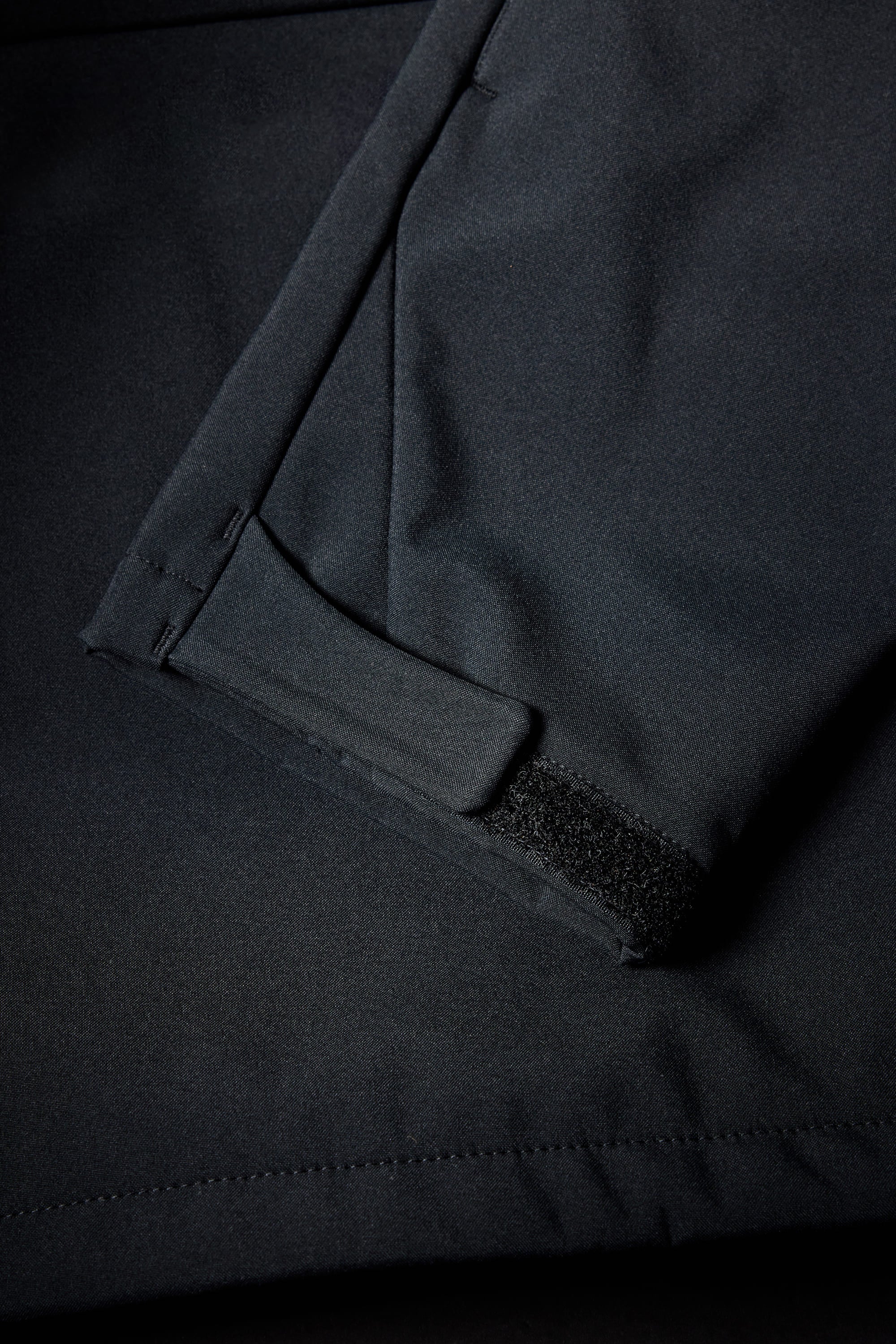Close-up of a 686 Mens Waterproof Slapshot Hoody sleeve featuring a Velcro cuff strap, with part of a pocket and seam visible in the background.