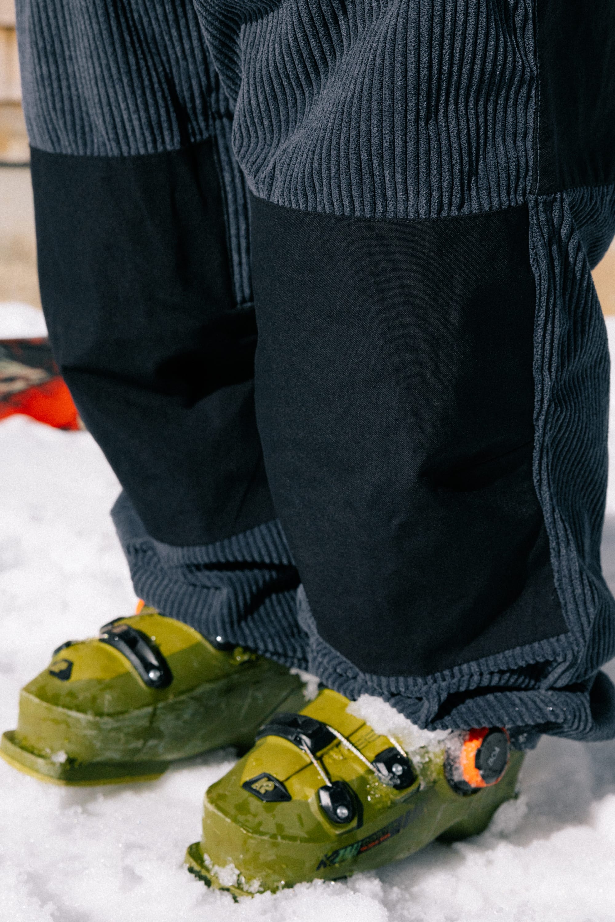 Close-up of a person standing in snow, wearing the 686 Ghost™ 2.5L Pant and green ski boots.