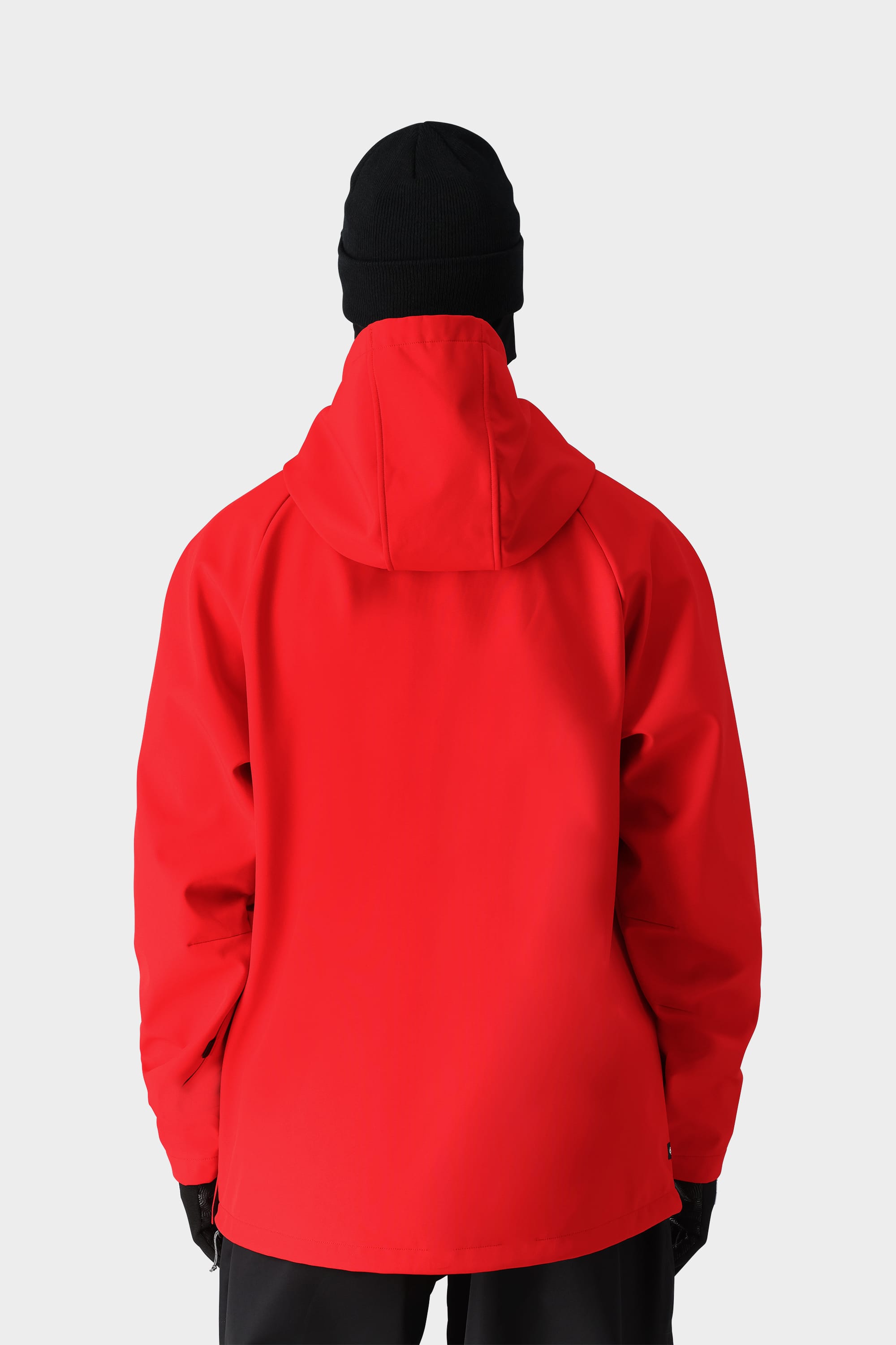 A person is shown from the back wearing the 686 Men’s Waterproof Hoody by 686, paired with black gloves and a black beanie, standing against a plain light gray background.
