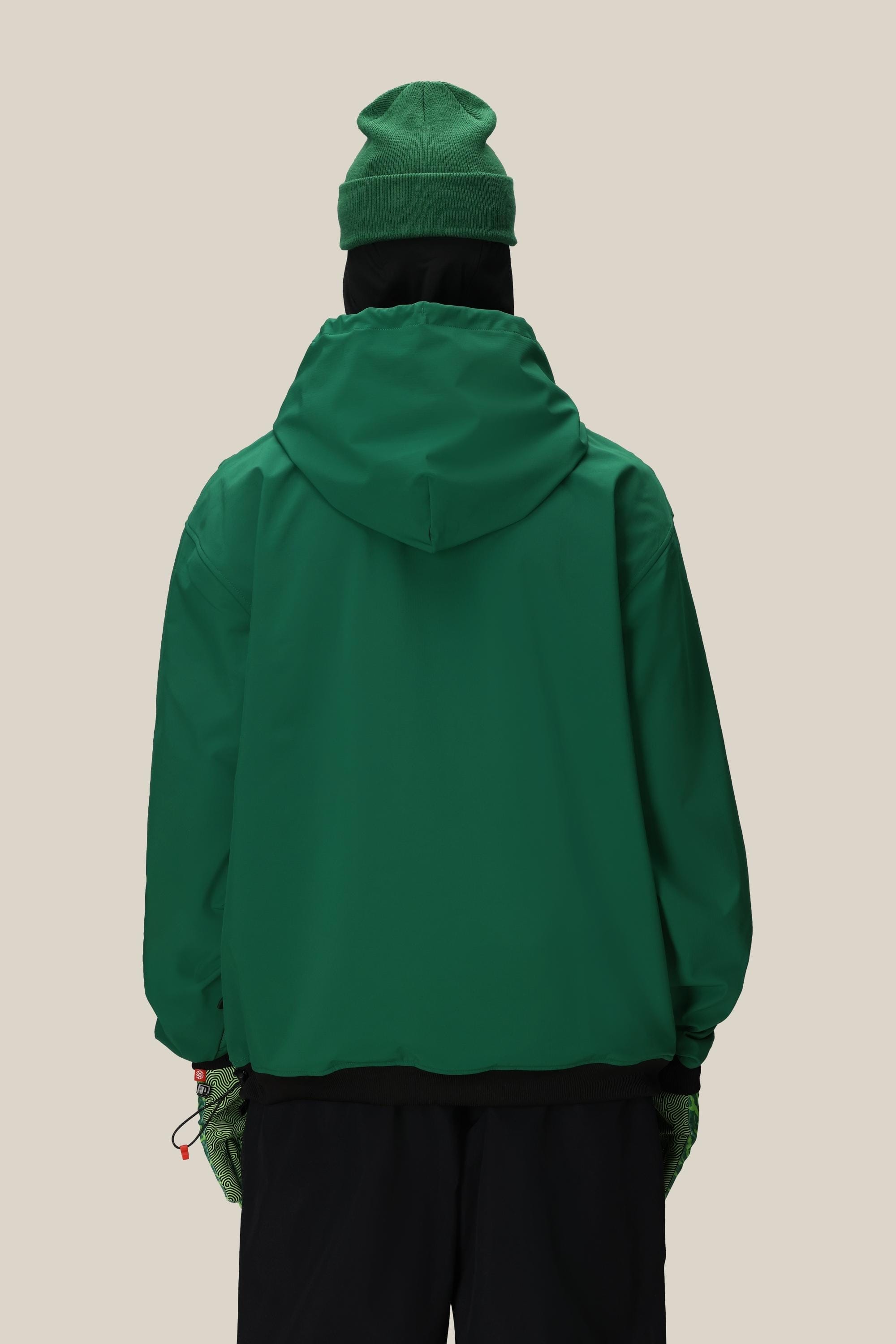 Wearing the 686 Mens Waterproof Team Hoody, a person in patterned pants uses a yellow payphone outdoors on a snowy, foggy mountain, with their back to the camera.