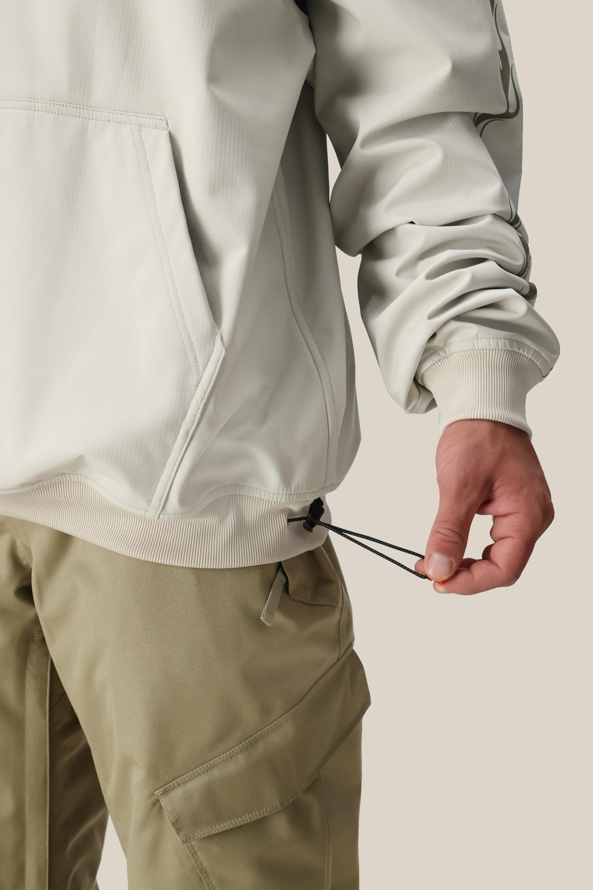 A person wearing a black beanie, black gloves, and the 686 Mens Waterproof Team Hoody with a circular hood graphic stands facing away on a plain white background, showcasing the mountain-inspired style by 686.