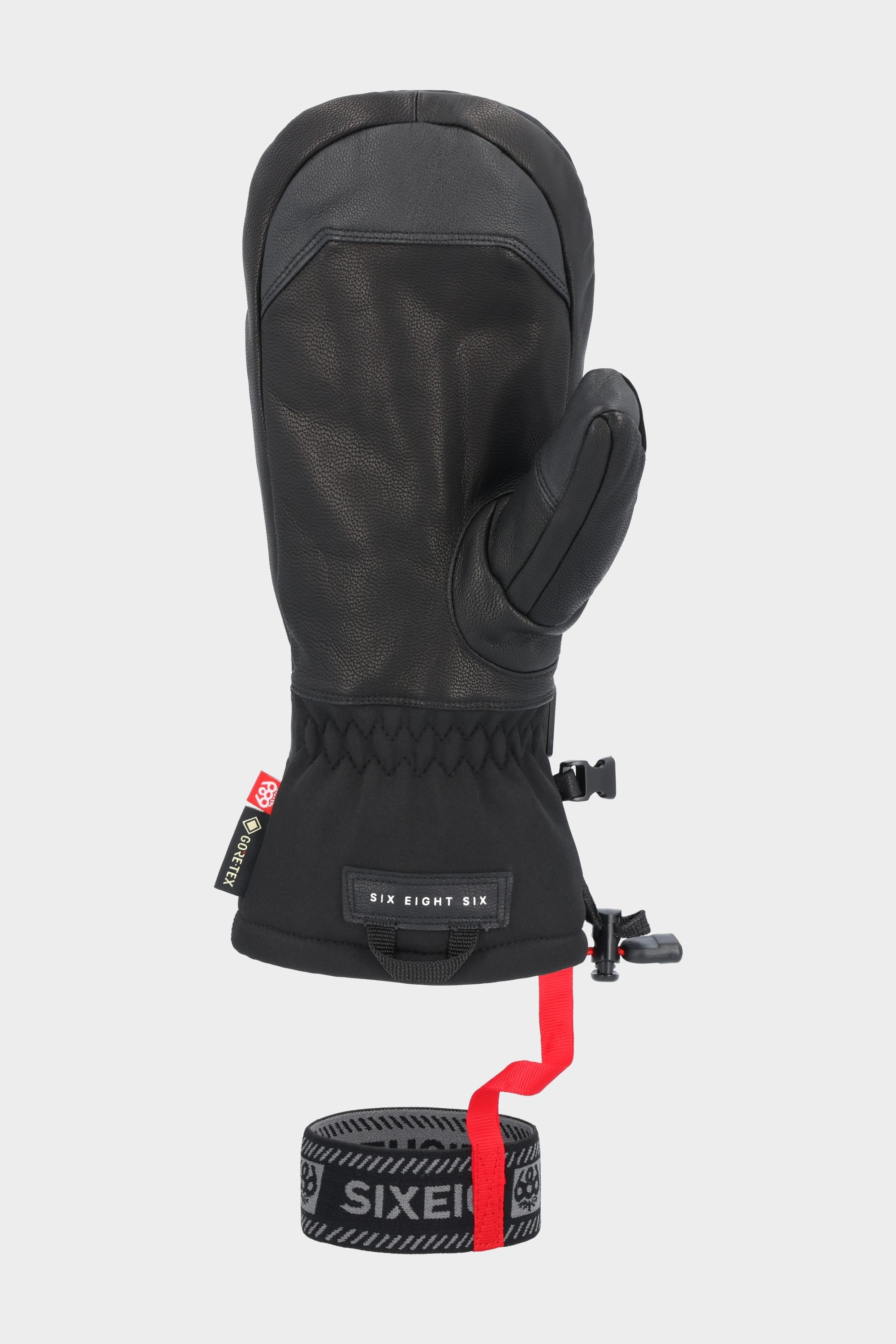 The 686 Mens GORE-TEX Leather Linear Mitt is a black woven mitt with a textured leather palm, adjustable wrist strap, and a removable gray elastic leash printed with “SIX EIGHT SIX.” Brand: 686.