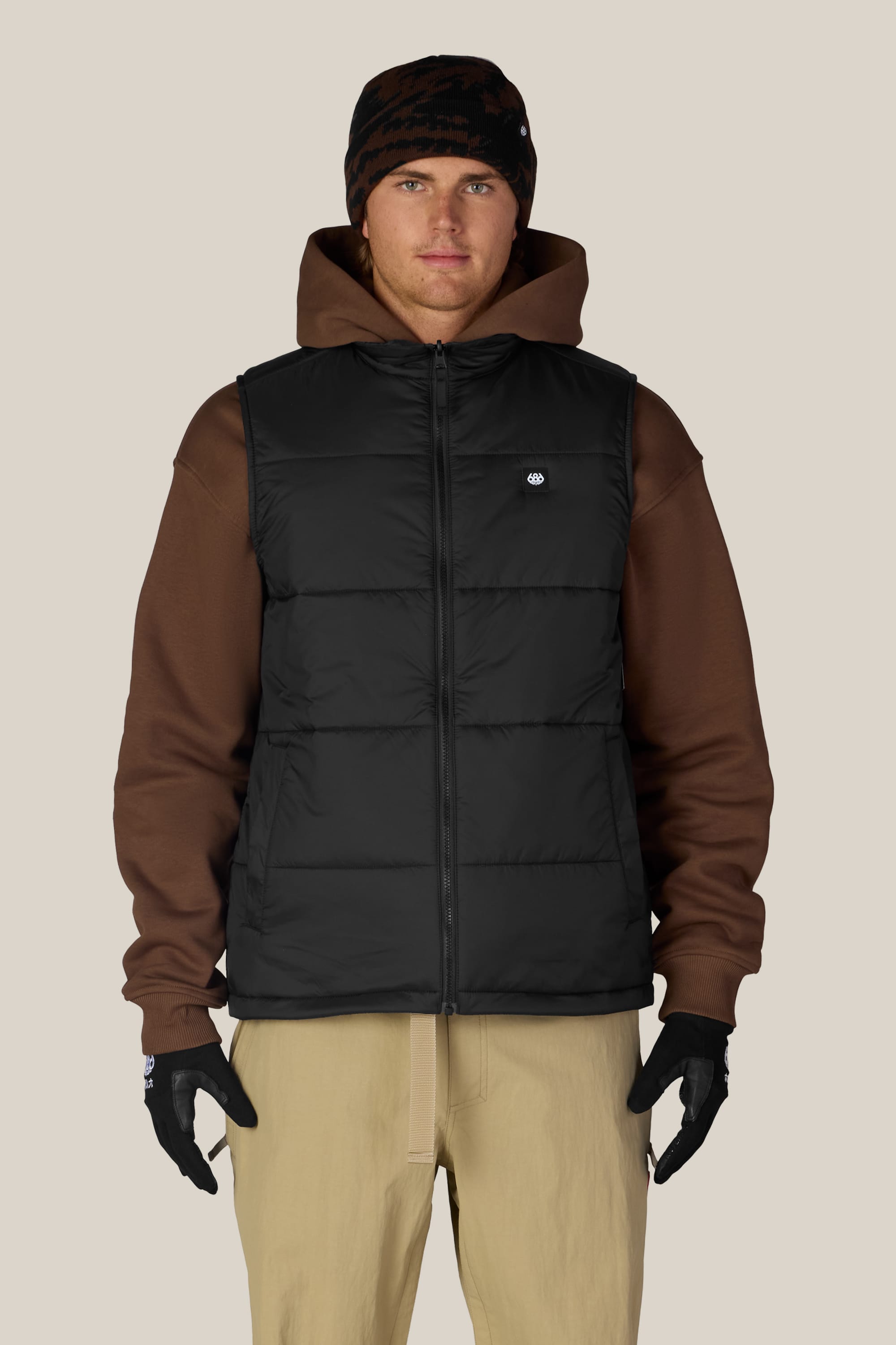 A person stands facing forward against a plain background, wearing the 686 Men’s SMARTY® 3-In-1 Rodeo™ 3L Jacket.