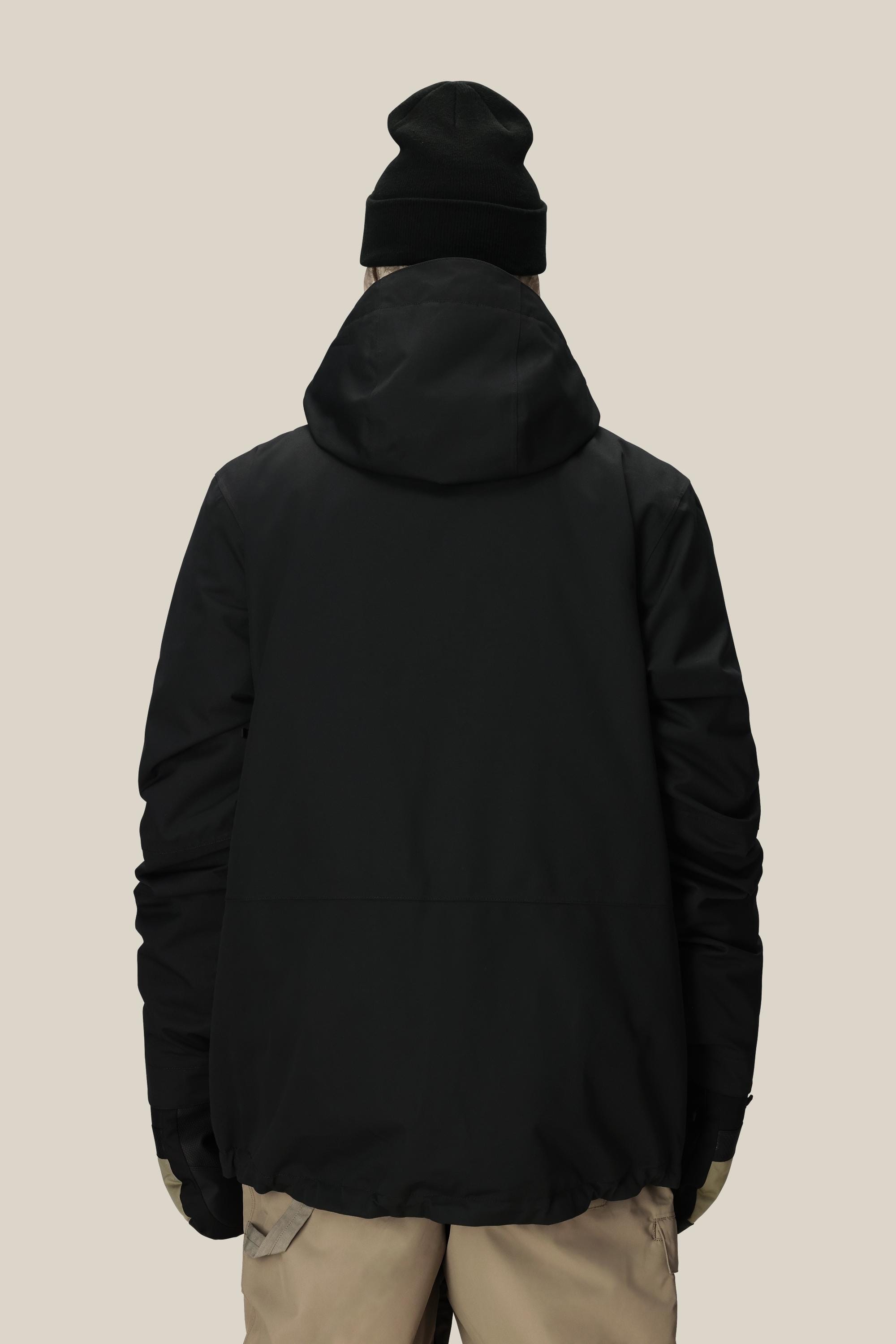 A person wearing the 686 Mens Smarty 3-In-1 Form Jacket, beige pants, green gloves, and a black beanie stands facing away against a plain light background.