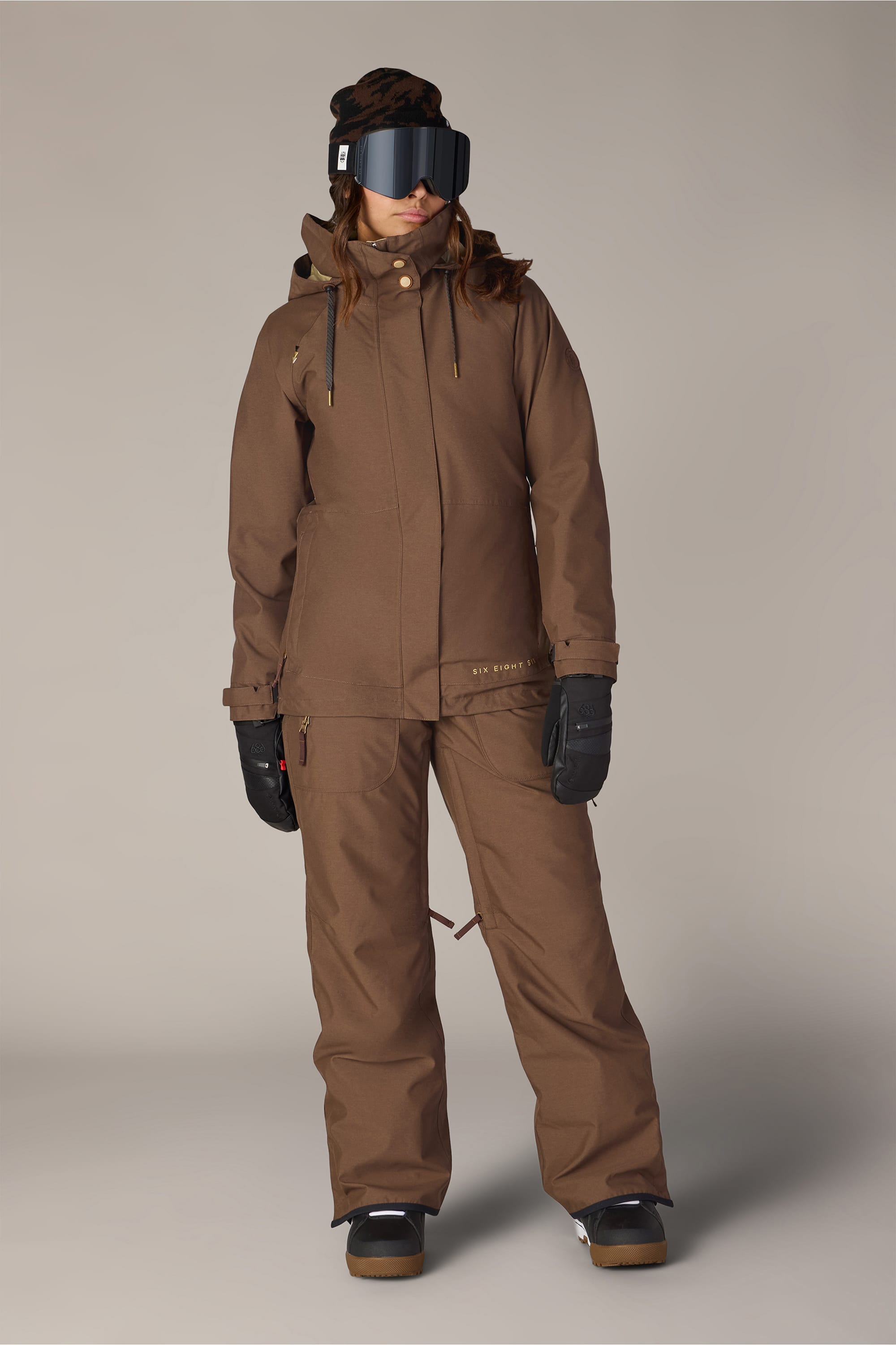 A person wearing the 686 Women’s Black Magic™ Insulated Bib stands against a neutral background.