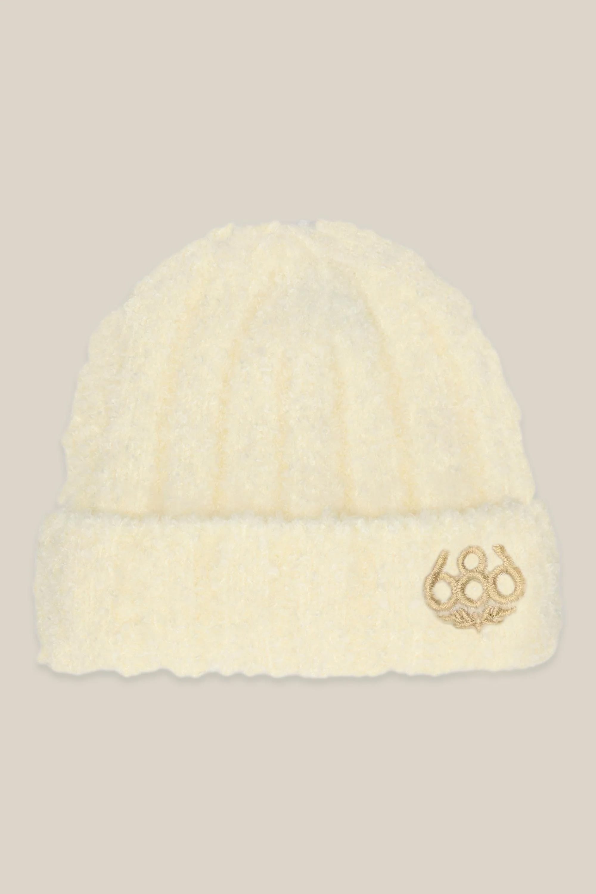 The 686 Women's Fuzzy Beanie is a soft, cream knit hat with a folded brim and a gold 686 logo patch on the front.