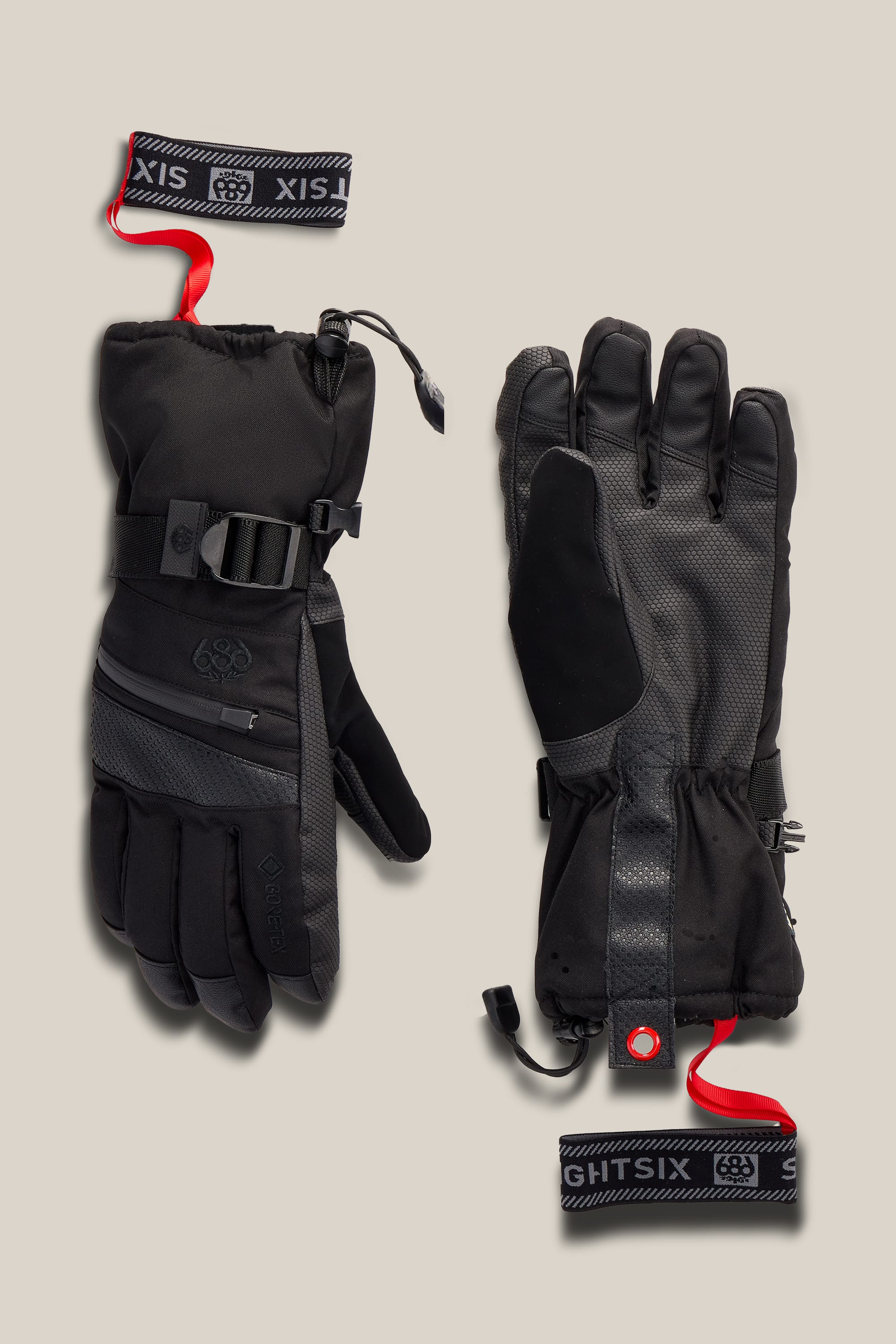 A pair of 686 Women’s GORE-TEX® SMARTY® 3-In-1 Gauntlet Gloves, featuring adjustable straps, textured grips, and red looped wrist leashes, displayed on a neutral background.