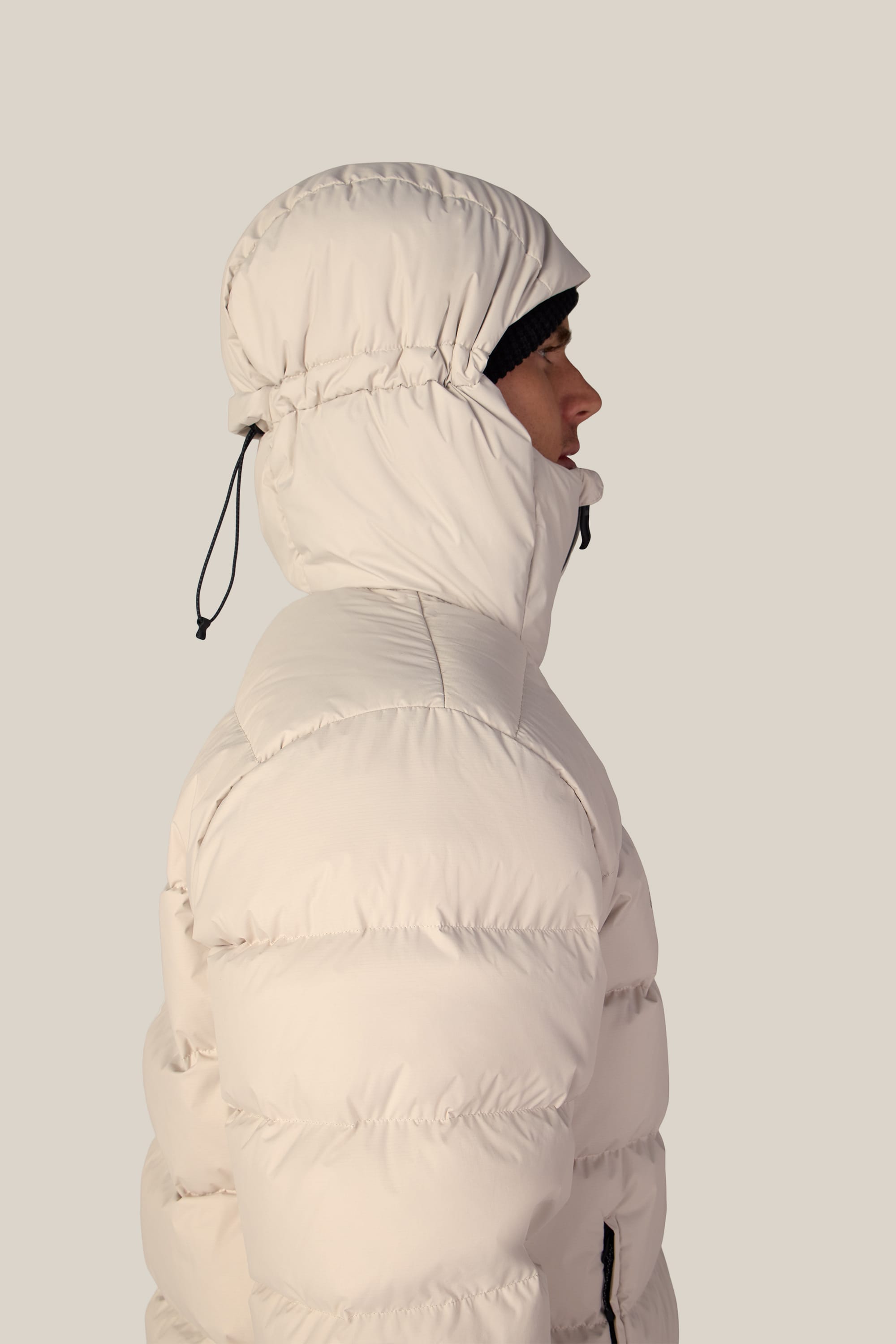 A person in profile view wearing the 686 Men’s WINDSTOPPER® Pyro™ Down Puffer Jacket by GORE-TEX® LABS with the hood up, against a plain light background.