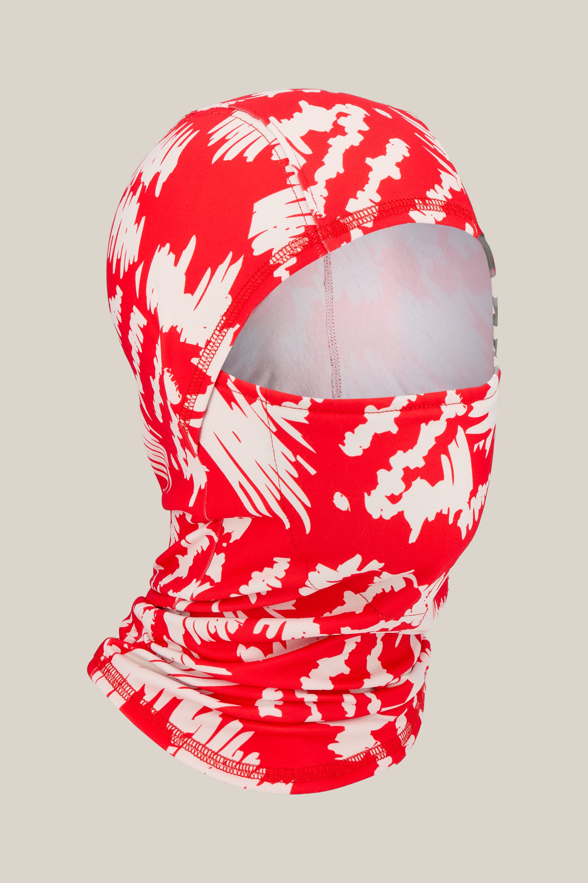 The 686 Hurra Hinged Balaclava by 686, a unisex facemask crafted from soft merino wool, features a red and white abstract pattern. Displayed on a neutral background, the full head covering showcases its face opening and interior fabric.