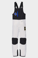 The 686 Youth Exploration Insulated Bib by 686 features a NASA theme in white and black, adjustable shoulder straps, front zipper pocket, NASA chest patch, reinforced black knees, and a rectangular patch on the left thigh.