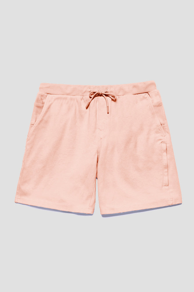 The 686 Mens Everywhere Double Knit Short by 686 in light pink features a casual drawstring waist, side pockets, and a right-side zipper detail, shown laid flat on a light grey background.