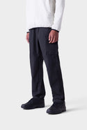 A person wearing the 686 Mens All Time Cargo Pant - Wide Tapered Fit in black stands against a plain white background, with the focus on their lower half from shoulders down.