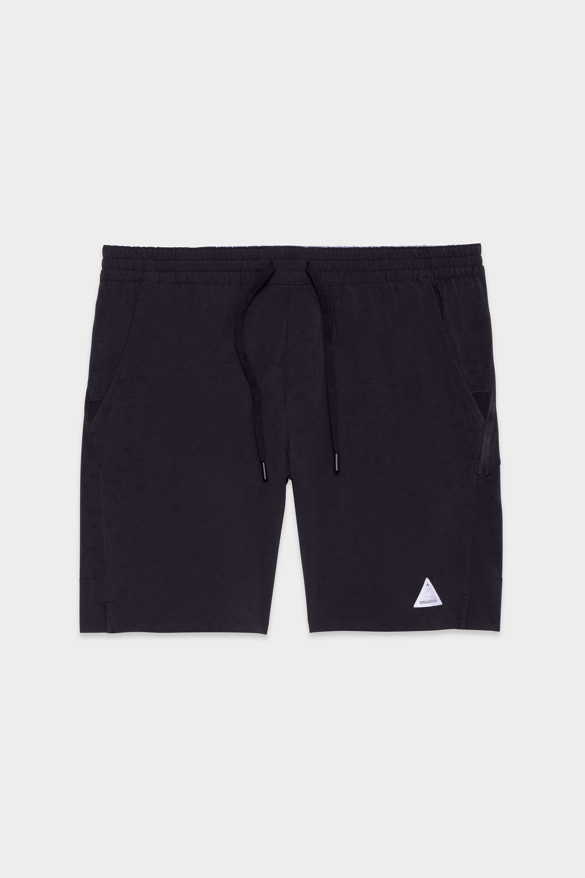 The 686 Mens ATP Stretch Performance Short features an elastic waistband with drawstring, side pockets, and a small white triangle logo on the front left leg. These black shorts by 686 are shown laid flat on a light gray background.