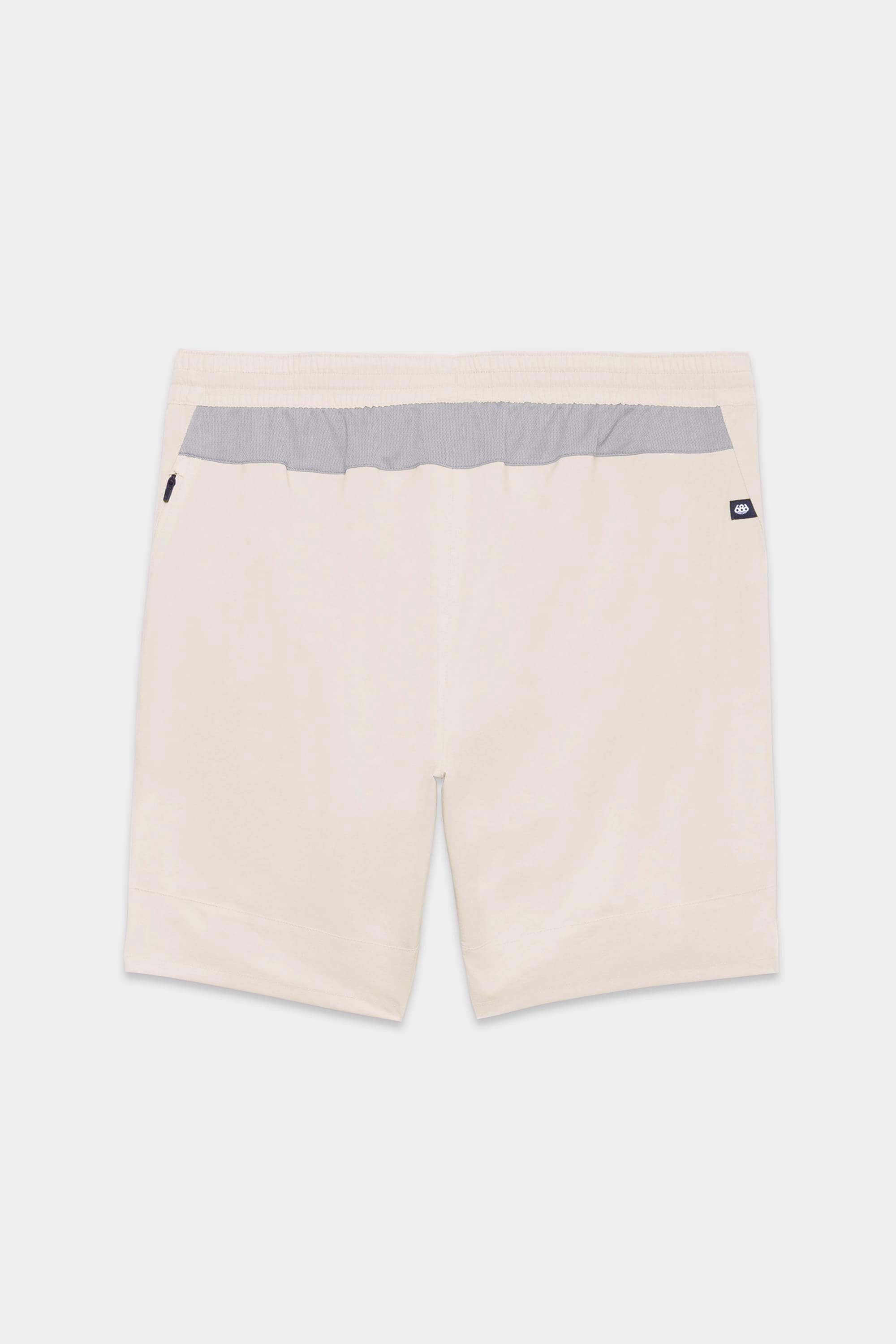 The 686 Mens ATP Stretch Performance Short by 686 features beige fabric, an elastic waistband, a light gray back panel, and a black and white logo tag on the right pocket. Displayed on a plain white background.