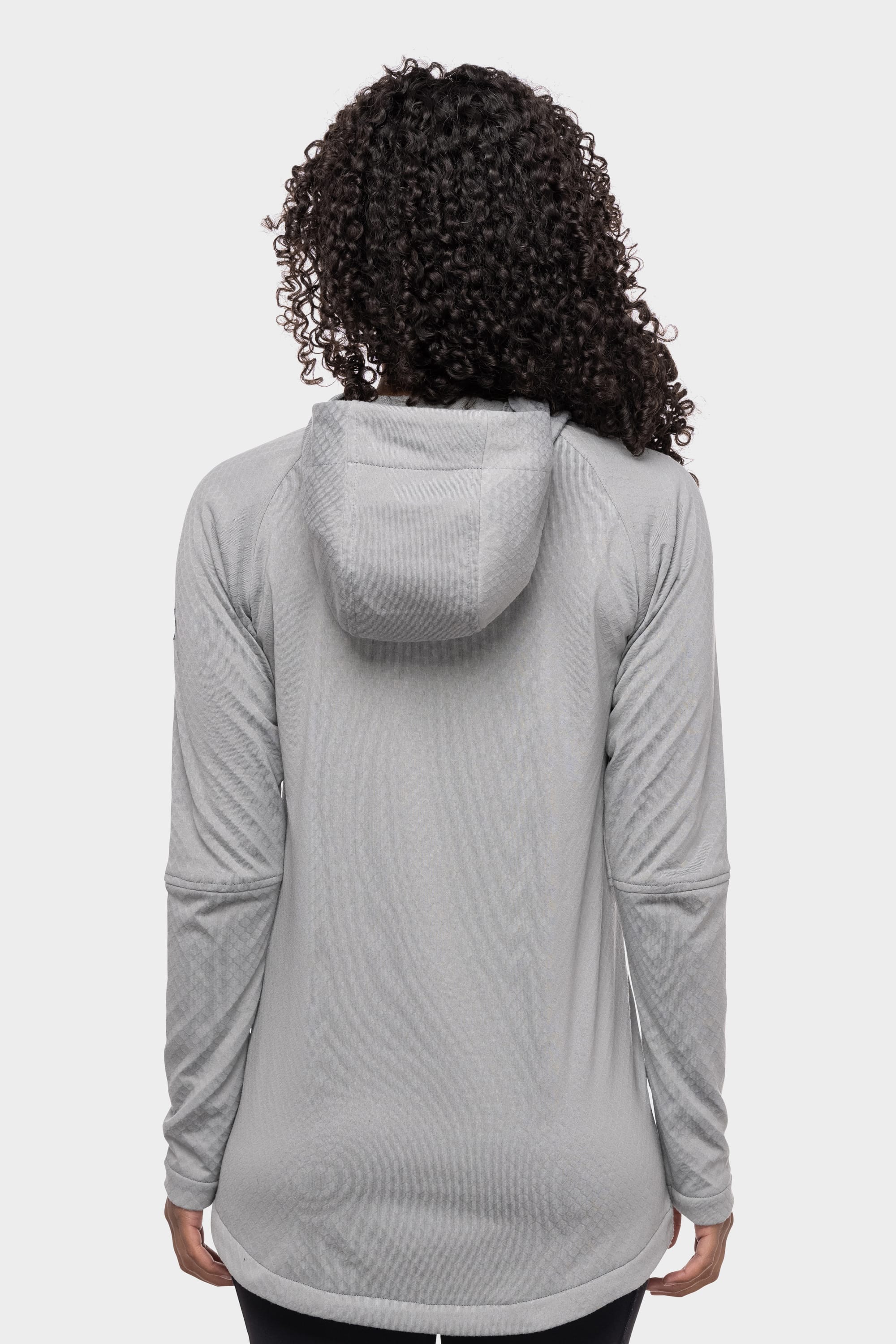 A person with curly hair is shown from the back wearing the 686 Womens Mission Grid Fleece Hoody in light grey by 686, against a plain white background.