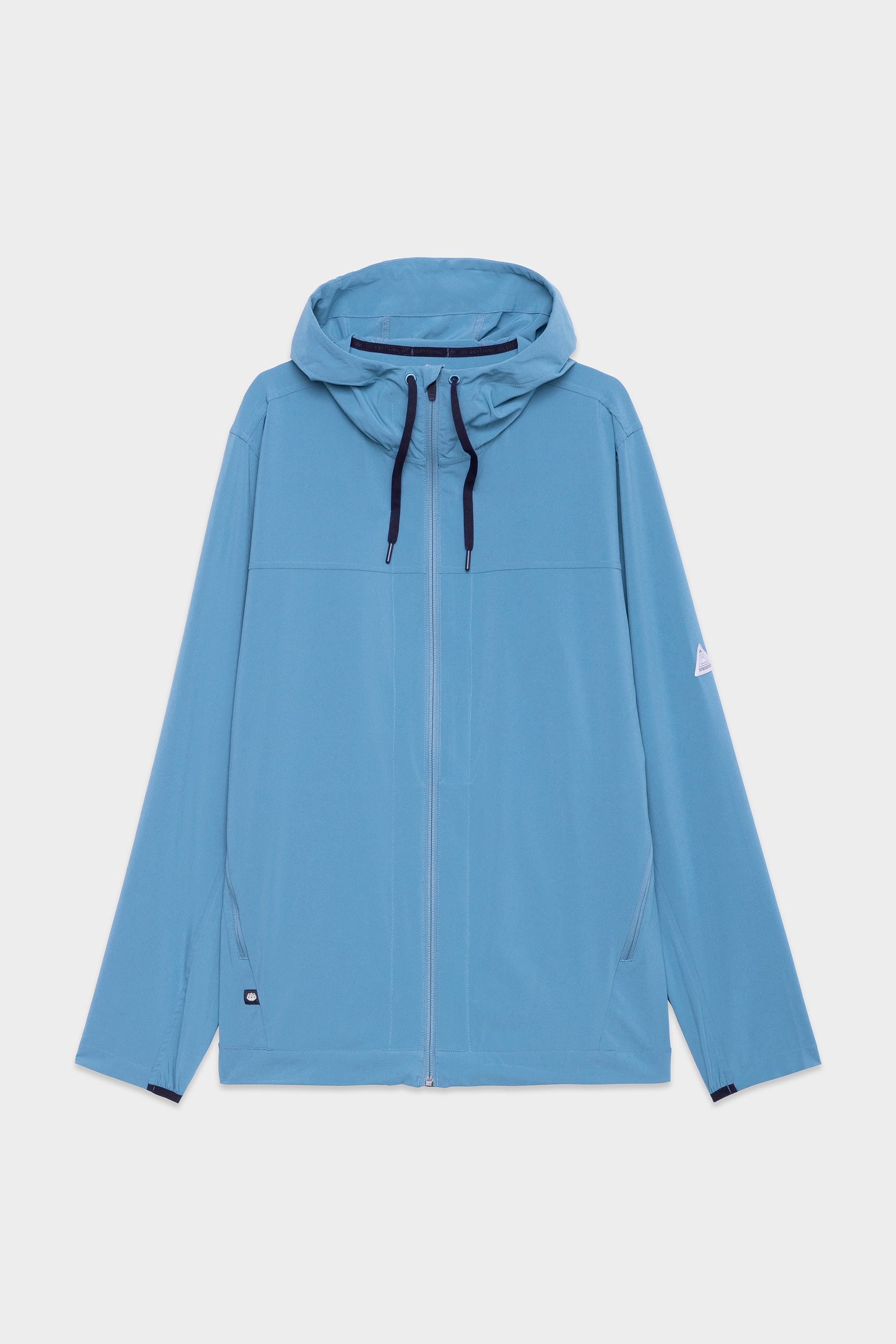 The 686 Mens ATP Stretch Wind Jacket by 686 features a light blue color, front zipper, navy blue drawstrings, long sleeves, and a small white patch on the left upper arm, shown on a plain white background.